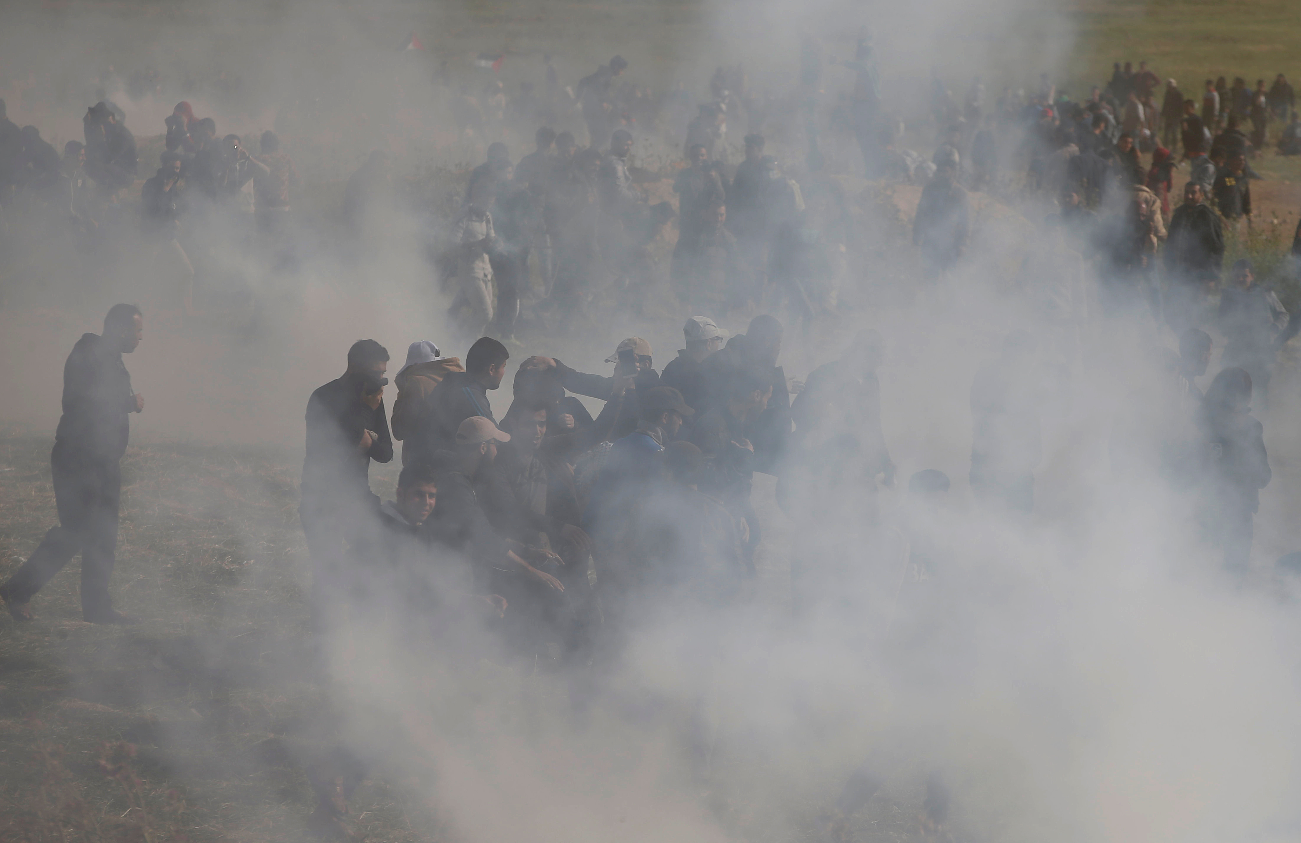 Palestinians run from tear gas fired by Israeli troops during clashes, during a tent city protest along the Israel border with Gaza, demanding the right to return to their homeland, east of Gaza City Friday. (Reuters)