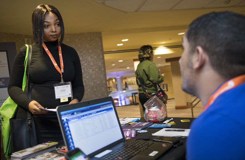 At a recent National LGBTQ Task Force conference in Washington D.C., Luis Felipe Cebas (right) from Whitman-Walker Health, talks with Sarah Fleming about PrEP, the pre-exposure drug that can help protect against HIV infection. (Tyrone Turner/ WAMU)