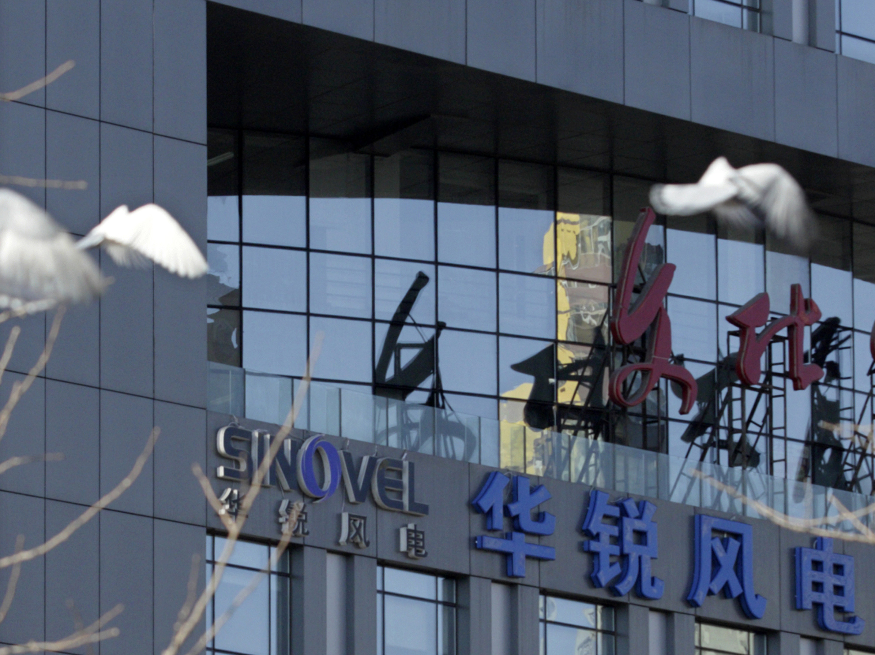 Pigeons fly past the company logo of Sinovel Wind Co., Ltd. outside its head office in Beijing, in 2011. In January 2018, Sinovel was convicted in the U.S. of stealing trade secrets from American Superconductor. (Reuters)