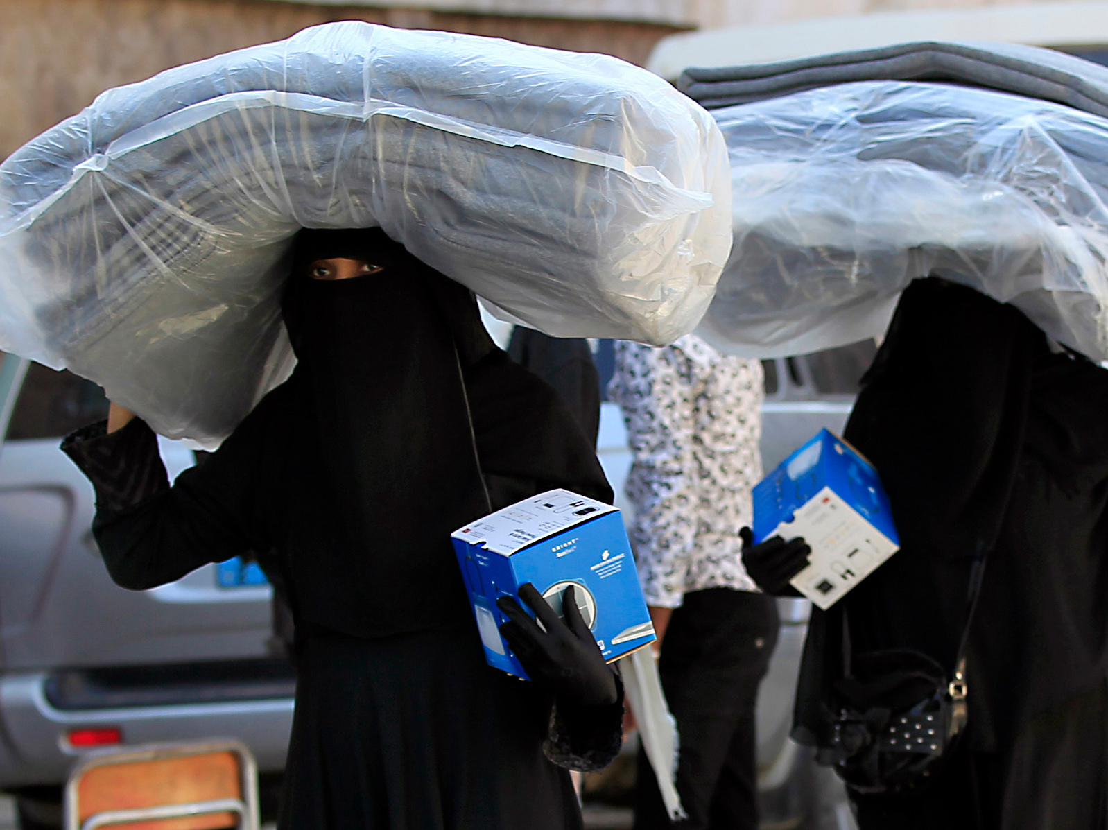 Yemeni women carry blankets and lanterns distributed by the United Nations High Commissioner for Refugees in Sanaa, Yemen. (AFP/Getty Images)