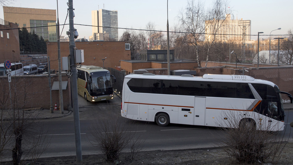 Buses believed to be carrying expelled diplomats leave the U.S. Embassy in Moscow on Thursday. The Kremlin ordered 60 American diplomats to leave Russia by Thursday, responding to a similar move by the U.S. (Pavel Golovkin/AP)
