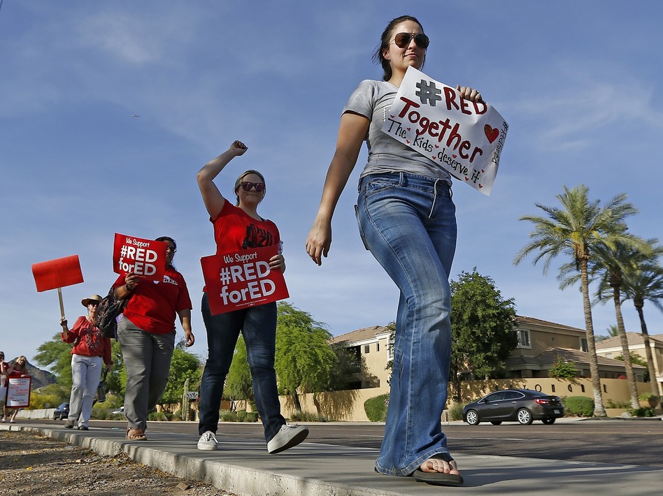 Arizona teachers marched in in front of a Phoenix radio station Tuesday, waiting for Republican Gov. Doug Ducey to show up for a live broadcast. (Ross D. Franklin/AP)