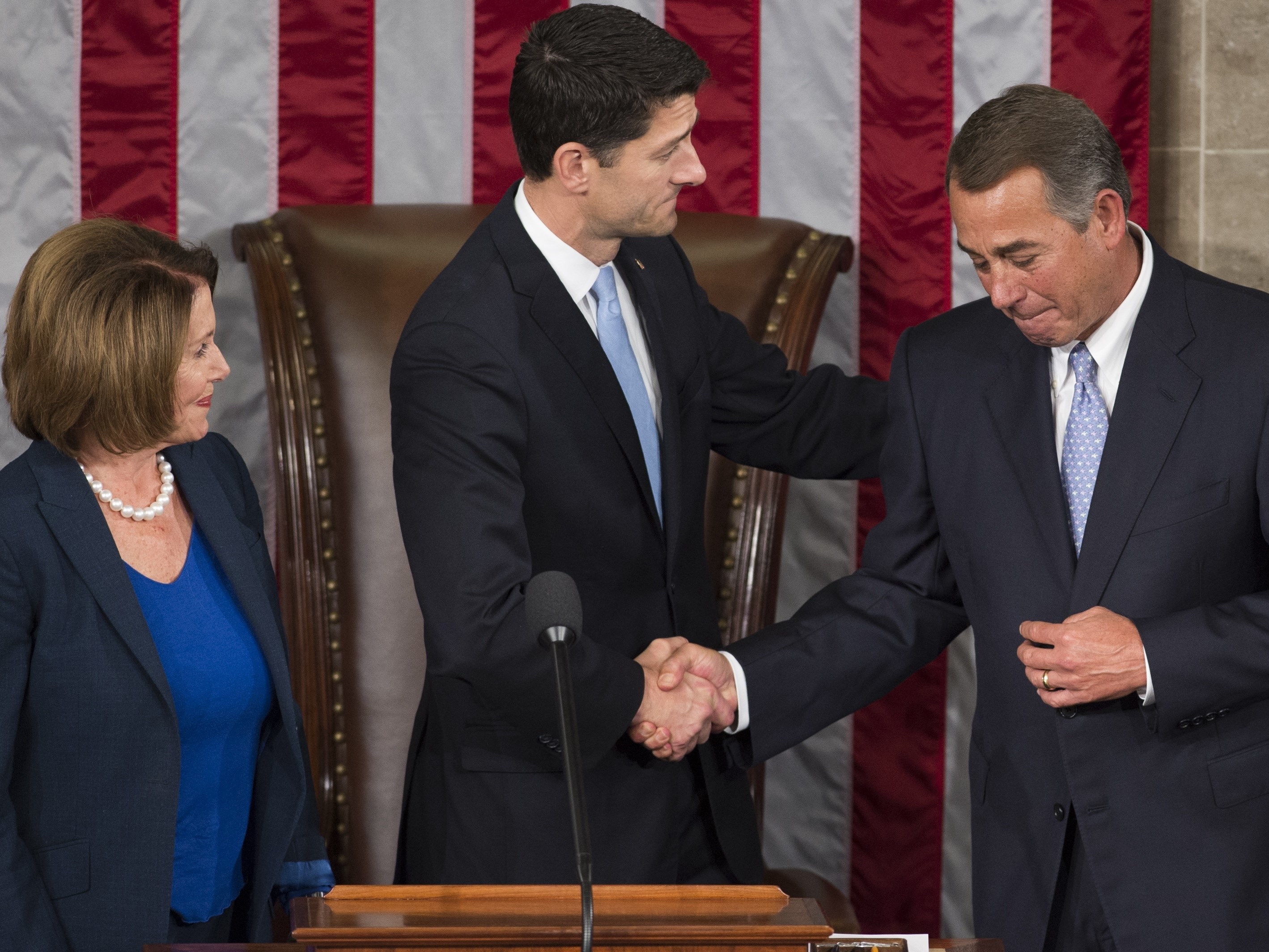 In 2015, newly elected Speaker of the House Paul Ryan shakes hands with outgoing Speaker John Boehner alongside House Democratic leader Nancy Pelosi at the U.S. Capitol.