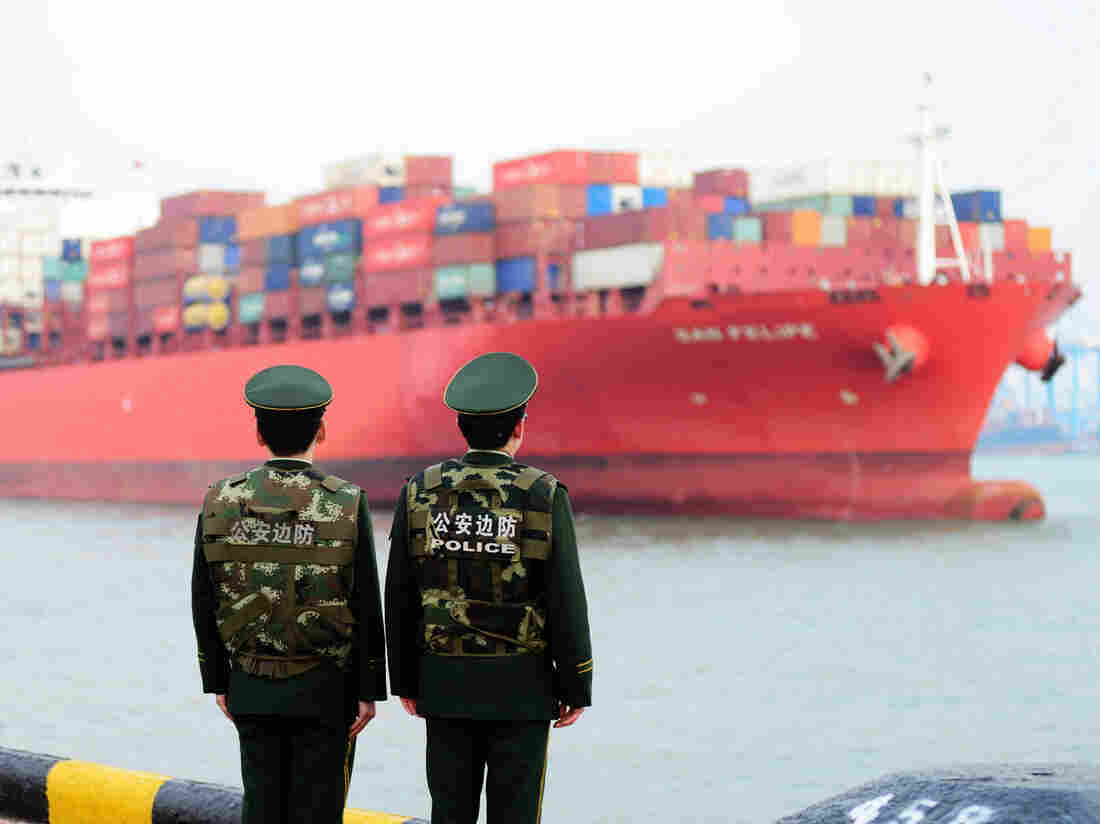 Chinese police officers watch a cargo ship at a port in Qingdao in China's eastern Shandong province on March 8, 2018.