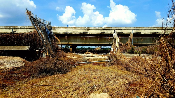 Floodwaters from Hurricane Harvey ripped apart fences and flooded Interstate 10 east of Houston last year. The San Jacinto Waste Pits Superfund site is on the other side of the road.