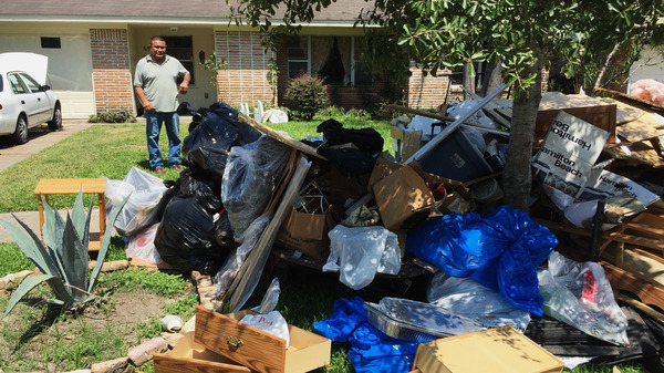 Salvador Cortez, surveys debris in his front yard in Houston after Hurricane Harvey last year.