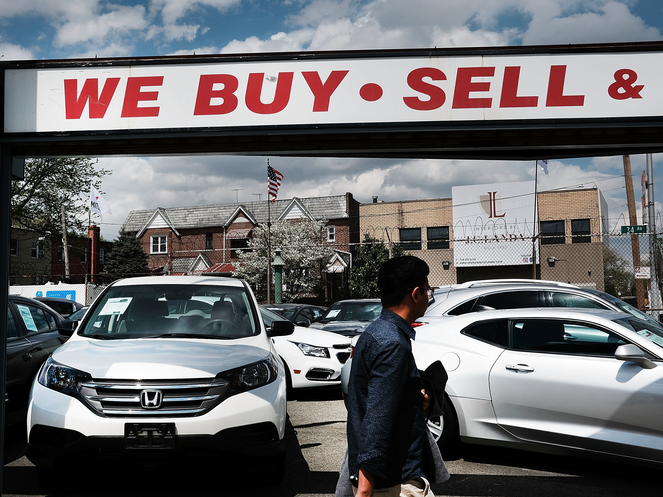 A man walks by a New York City auto dealership in 2017. Studies have found that African-Americans and Hispanics have systematically been charged a higher markup on auto loans than have white borrowers. (Getty Images)