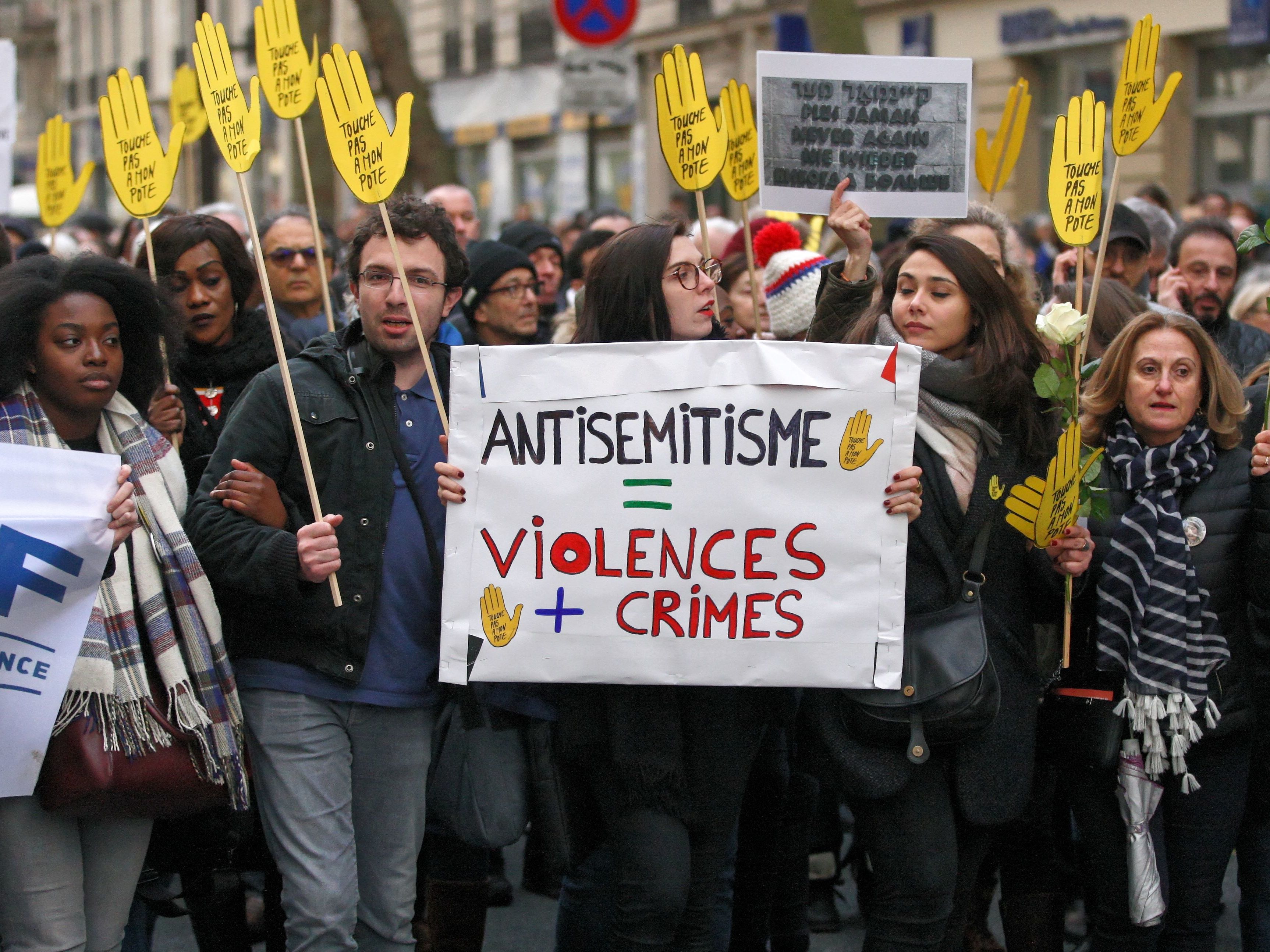 Demonstrators hold signs against anti-Semitism during a silent march in Paris on March 28 in memory of Mireille Knoll, an 85-year-old Jewish woman murdered in her home in what police believe was an anti-Semitic attack. Knoll escaped the mass deportation of Jews from Paris during World War II. (NurPhoto via Getty Images)