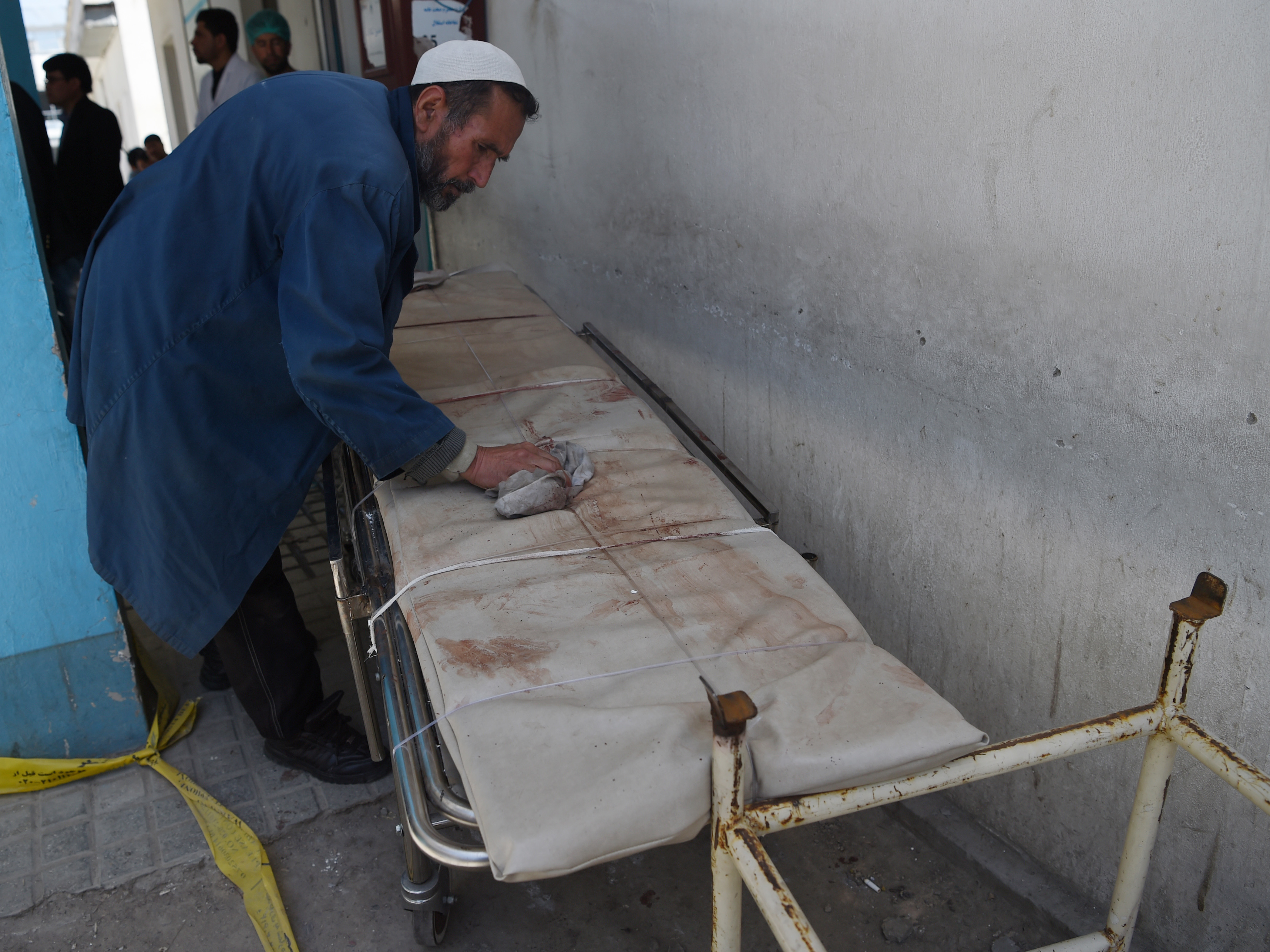 An Afghan member of medical staff cleans a stretcher following a suicide bombing attack in Kabul on April 22, 2018. (Photo by WAKIL KOHSAR / AFP) (Photo credit should read WAKIL KOHSAR/AFP/Getty Images)