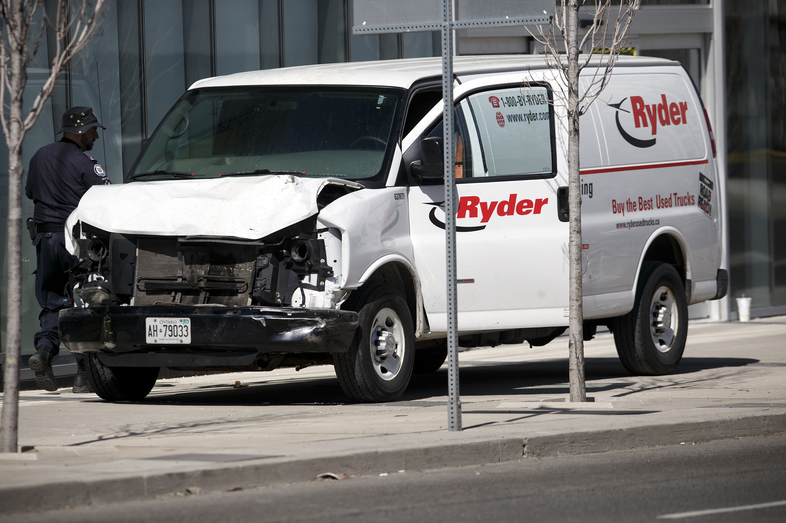 Police inspect a van suspected of being involved in a collision that killed at least 10 people and injured 15 others in Toronto on Monday. (Cole Burston/Getty Images)