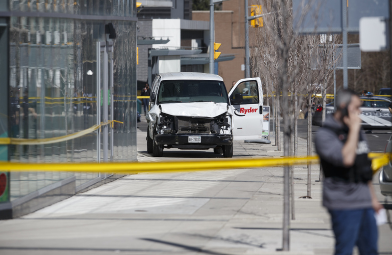 Police inspect a van used in a rampage that left at least 10 people dead Monday in Toronto. (Cole Burston/Getty Images)