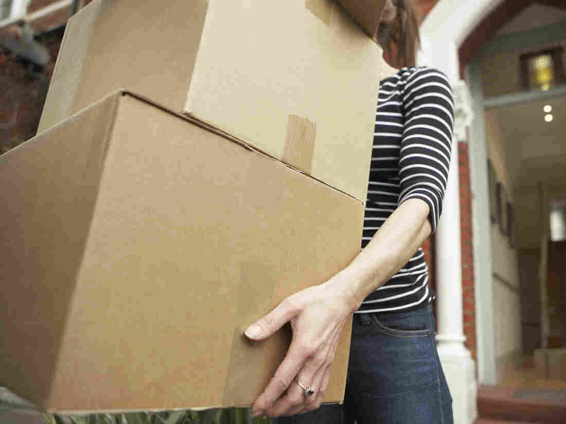 Woman holding unmarked boxes.