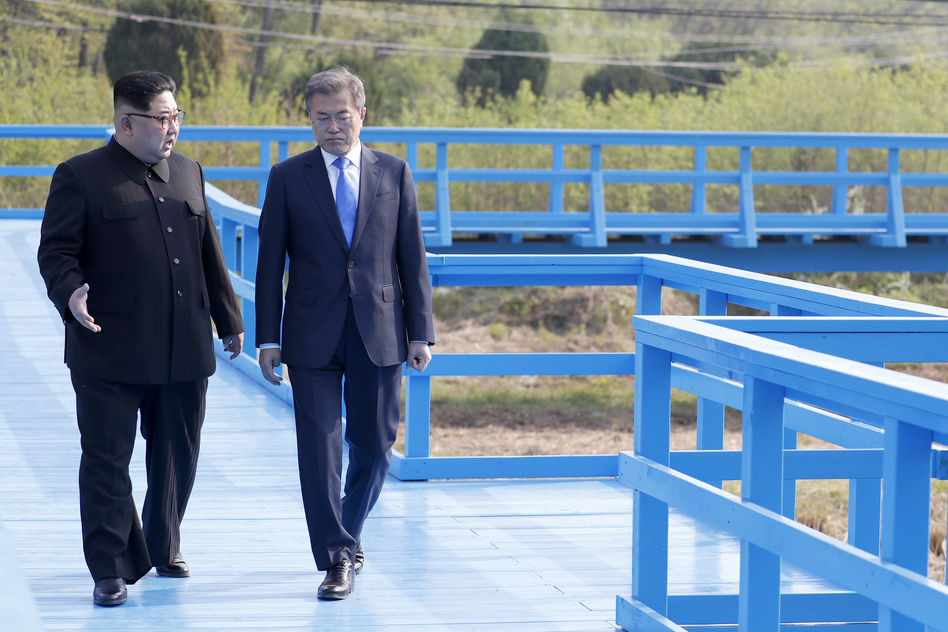 North Korea's leader Kim Jong Un (left) and South Korea's President Moon Jae-in walk on a bridge at the truce village of Panmunjom Friday. South Korea says Kim told Moon of the plan to shut the test site. (Korea Summit Press Pool via/AFP/Getty Images)