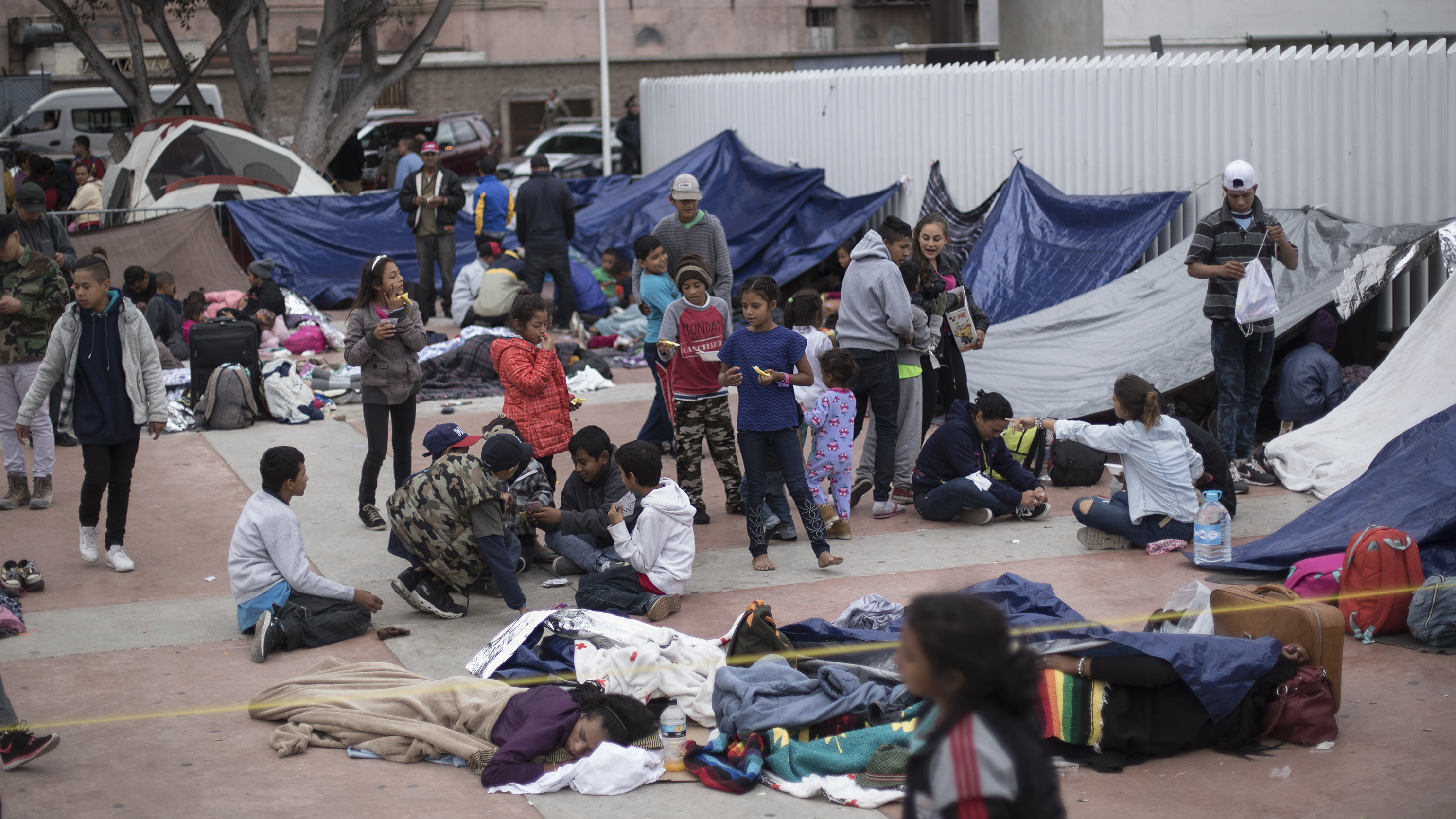 Migrants wait for access to request asylum in the U.S. at the El Chaparral port of Entry in Tijuana, Mexico, on Monday.