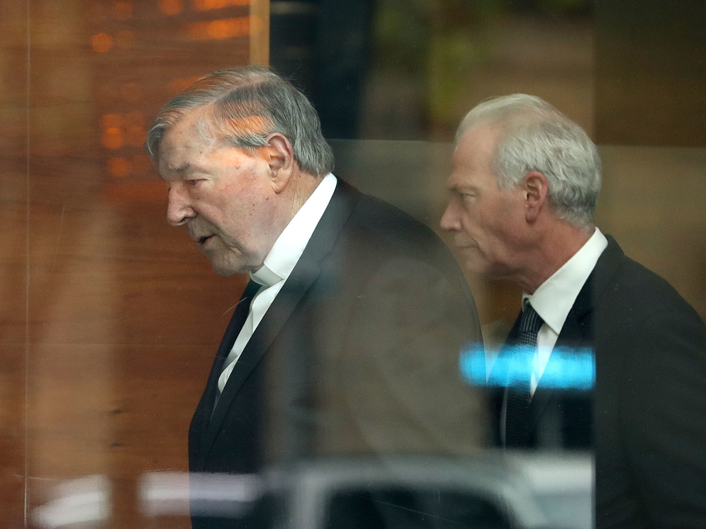Cardinal George Pell (left) leaves Melbourne Magistrates' Court on Wednesday in Melbourne, Australia. (Getty Images)