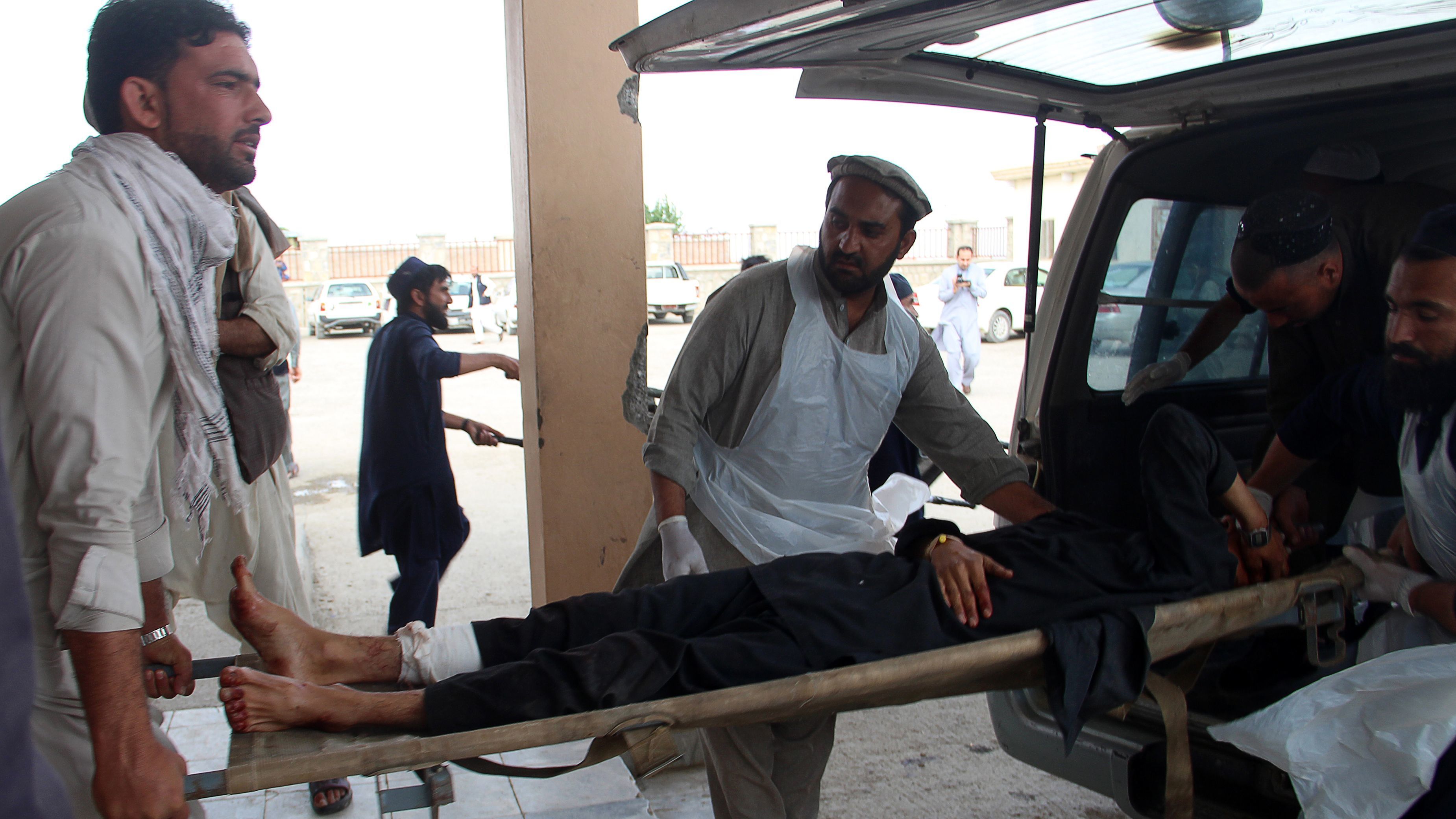 An Afghan man lays on a stretcher as others rush him to a hospital following blast at a mosque being used as a voter registration center in Khost Province on Sunday. (AFP/Getty Images)