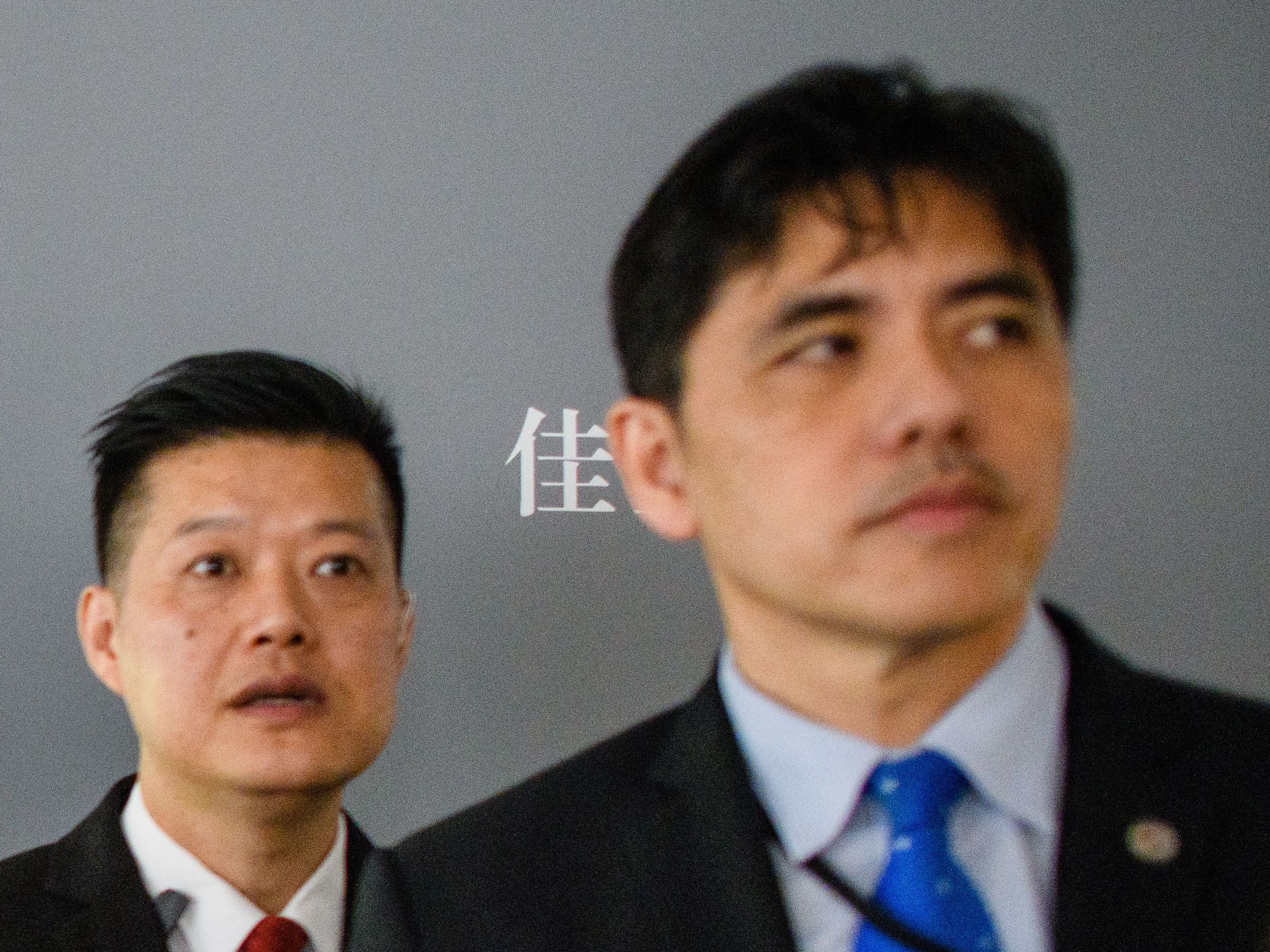 This 2017 photo shows the man on the right, identified by local Hong Kong media as former CIA agent Jerry Chun Shing Lee, standing in front of a member of security at the unveiling of Leonardo da Vinci's &quot;Salvator Mundi&quot; painting at the Christie's showroom in Hong Kong. (AFP/Getty Images)