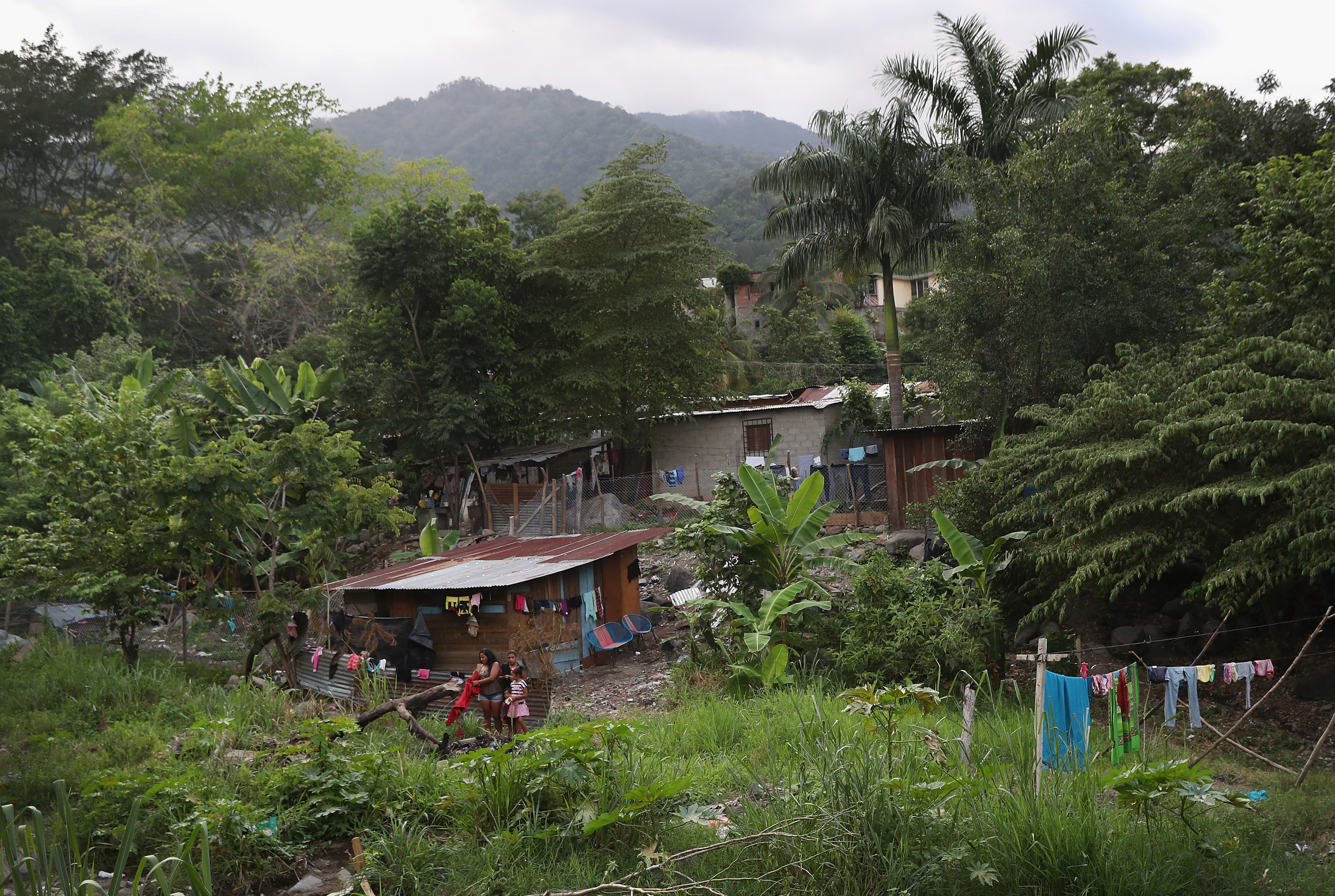 Families live by a creek in an impoverished neighborhood in San Pedro Sula, Honduras. (Getty Images)
