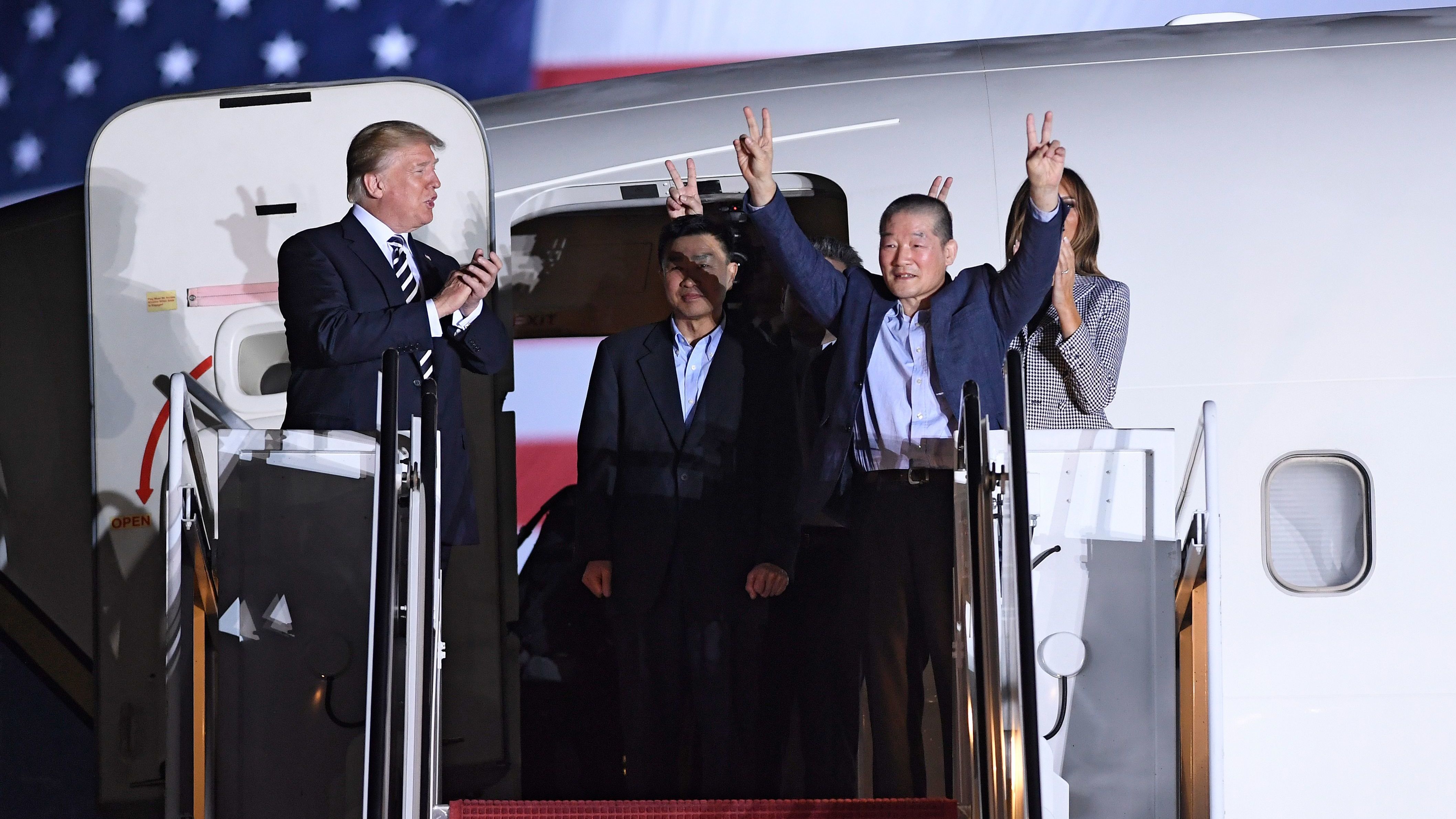 President Trump applauds as Kim Dong Chul (2nd R) gestures upon his return with Kim Hak Song (C) and Tony Kim (behind) after they were freed by North Korea, at Joint Base Andrews in Maryland. (AFP/Getty Images)