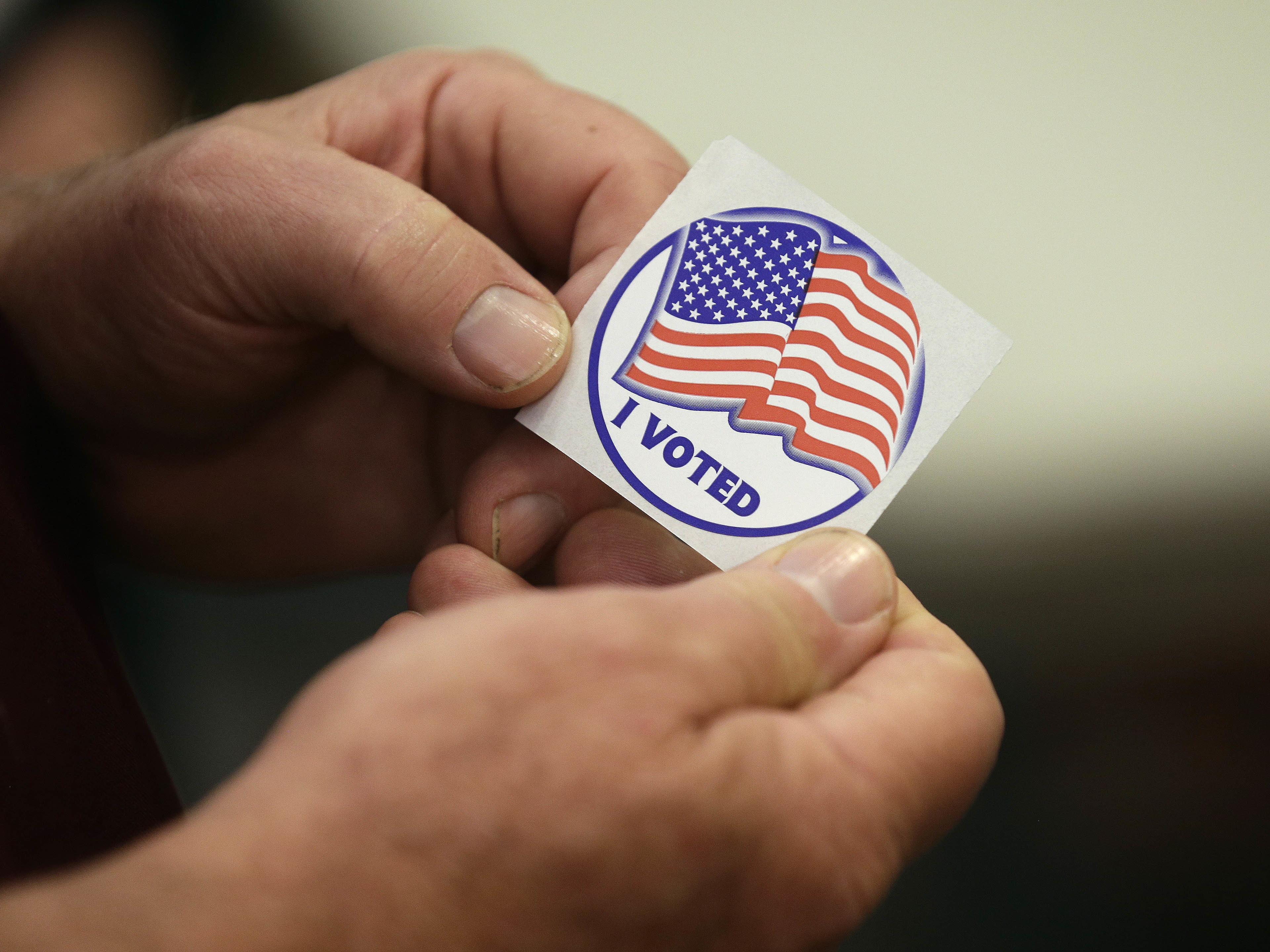 Rick Colyer holds a sticker after placing his vote at the Durham County Library North Regional in Durham, N.C., Tuesday.