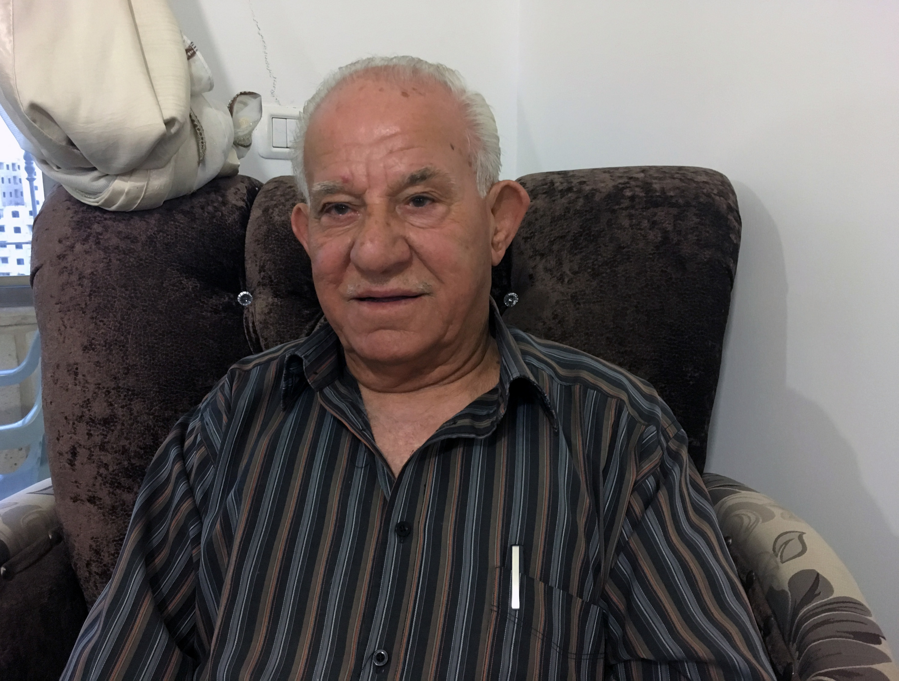 Akram Tamimi, 79, moved to a neighborhood behind the barrier to maintain his Jerusalem residency rights, but calls it "a prison."