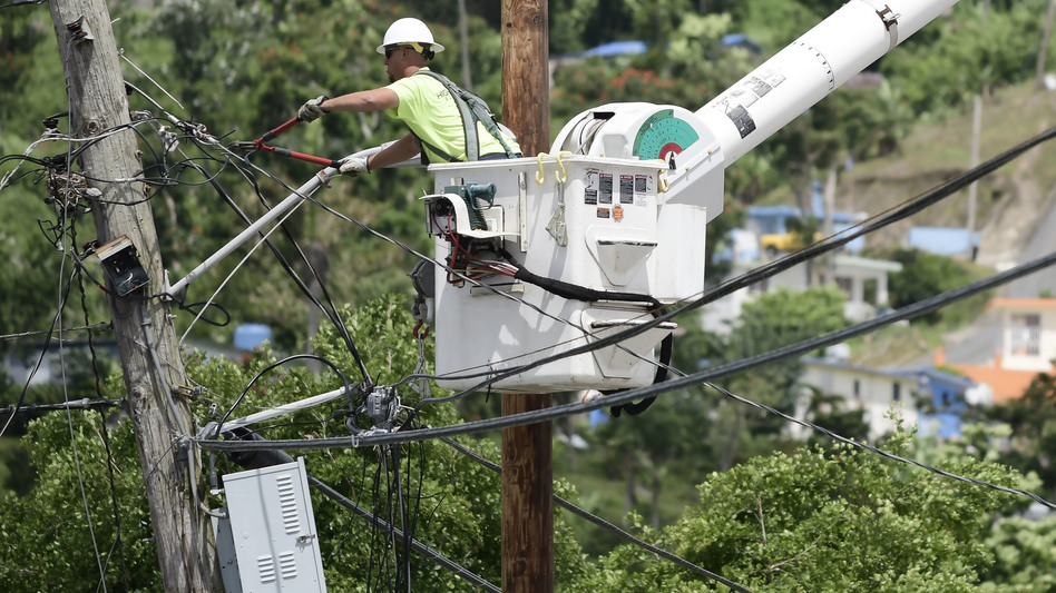 A worker from the Cobra Energy Company, contracted by the Army Corps of Engineers, installs power lines in the Barrio Martorel area of Yabucoa, a town where many residents continue without power in Puerto Rico, on May 16. (Carlos Giusti/AP)