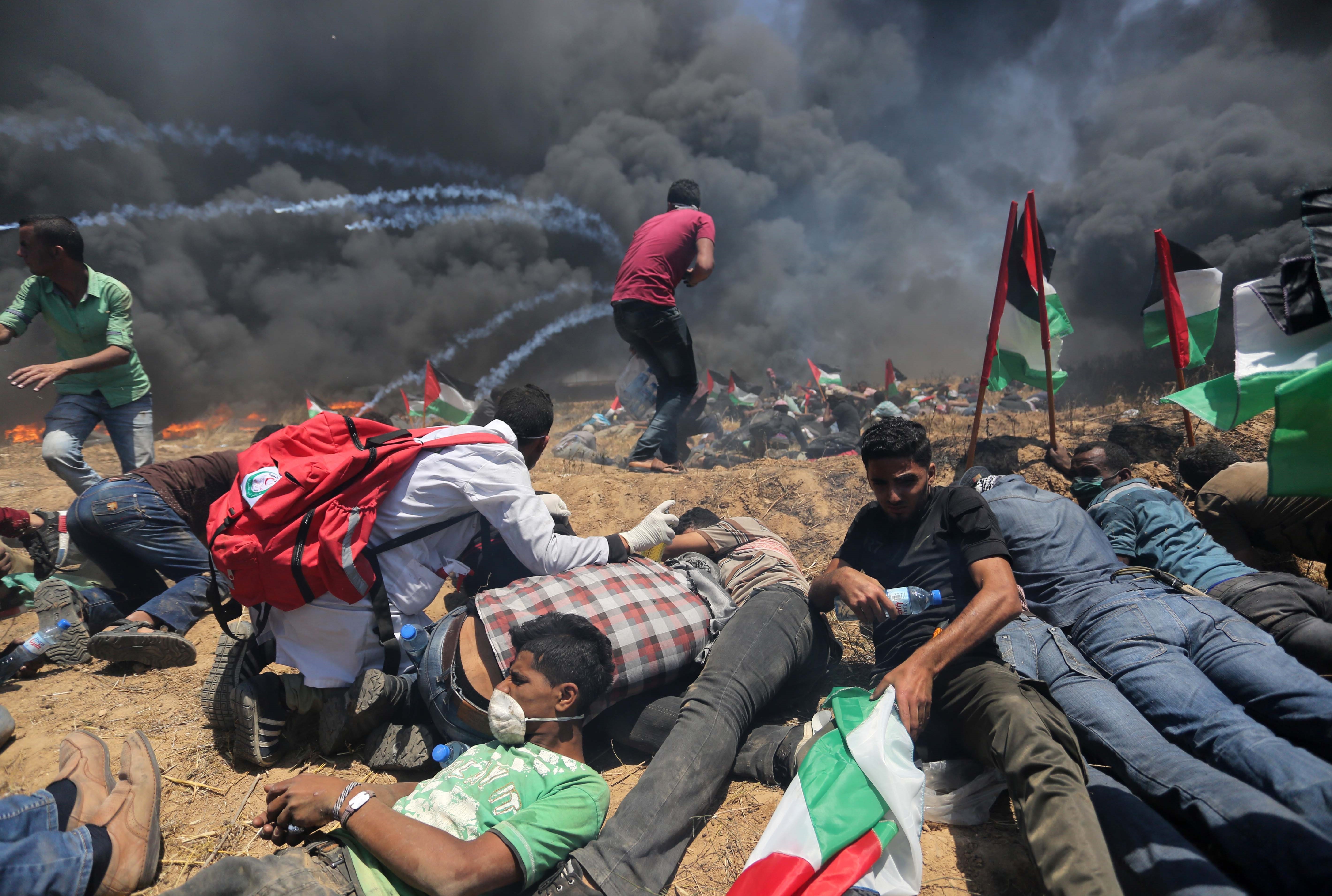 Palestinians set tires on fire, as Israeli soldiers attempt to prevent protesters from breaking through the Gaza-Israel border. The demonstration marked the 70th anniversary of Nakba, or catastrophe, a commemoration of the displacement of hundreds of thousands of Palestinians in the war surrounding Israel's creation. (Getty Images)