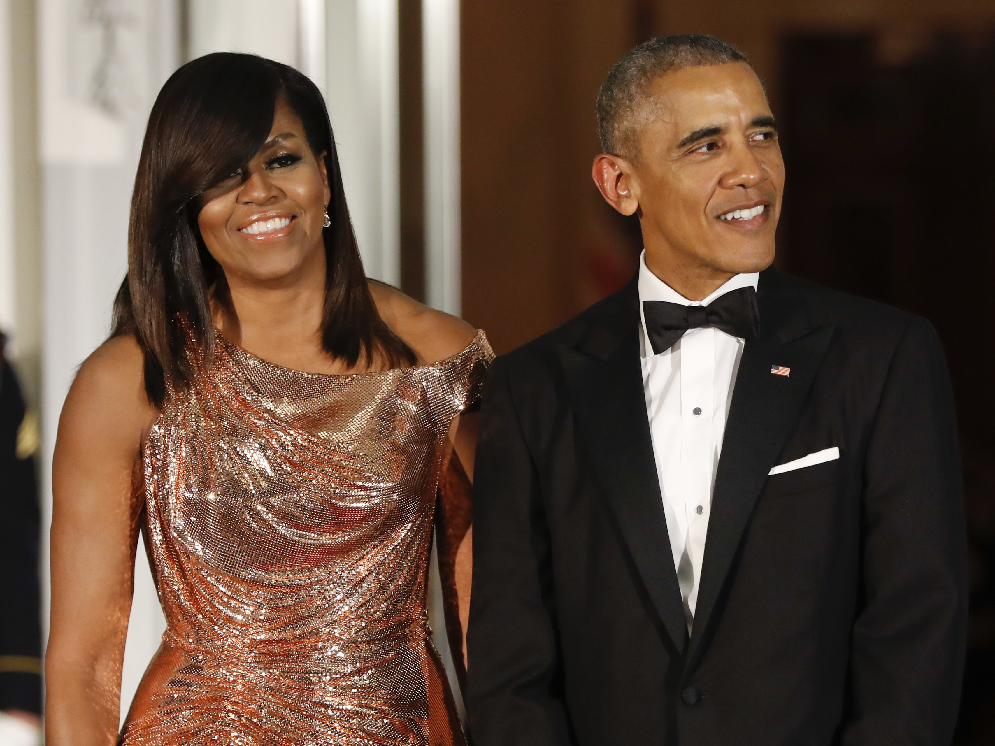 President Barack Obama and first lady Michelle Obama wait to greet Italian Prime Minister Matteo Renzi and his wife, Agnese Landini, for a State Dinner at the White House in Washington in 2016. Netflix says it has reached a deal with the Obamas to produce material for the streaming service.