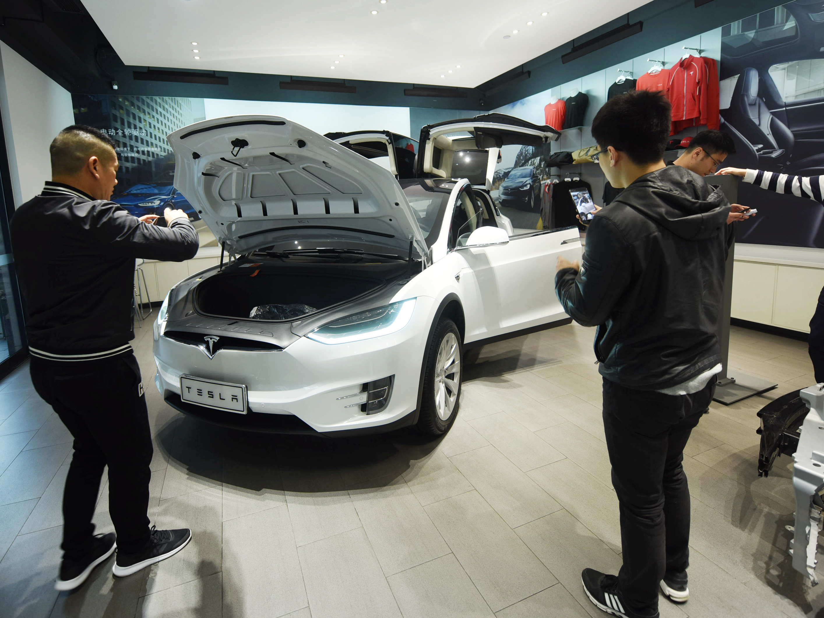 Customers look at Tesla cars at a showroom in Hangzhou in China's eastern Zhejiang province on April 4. The cut in Chinese auto import tariffs could help Tesla, which has been looking to break into the Chinese market. (AFP/Getty Images)