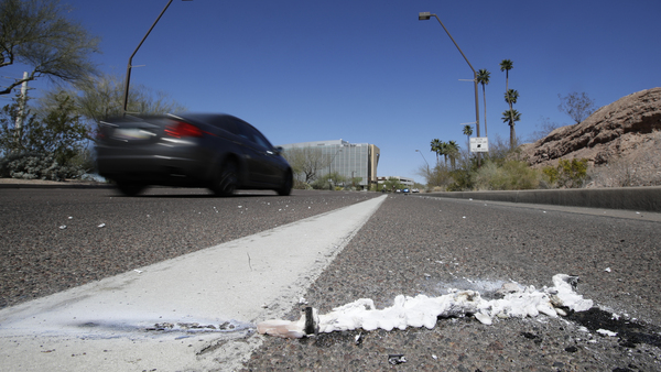 A vehicle drives by the spot where an Uber self-driving vehicle struck and killed a pedestrian earlier this year in Tempe, Ariz. The National Transportation Safety Board released a preliminary report Thursday on the collision.