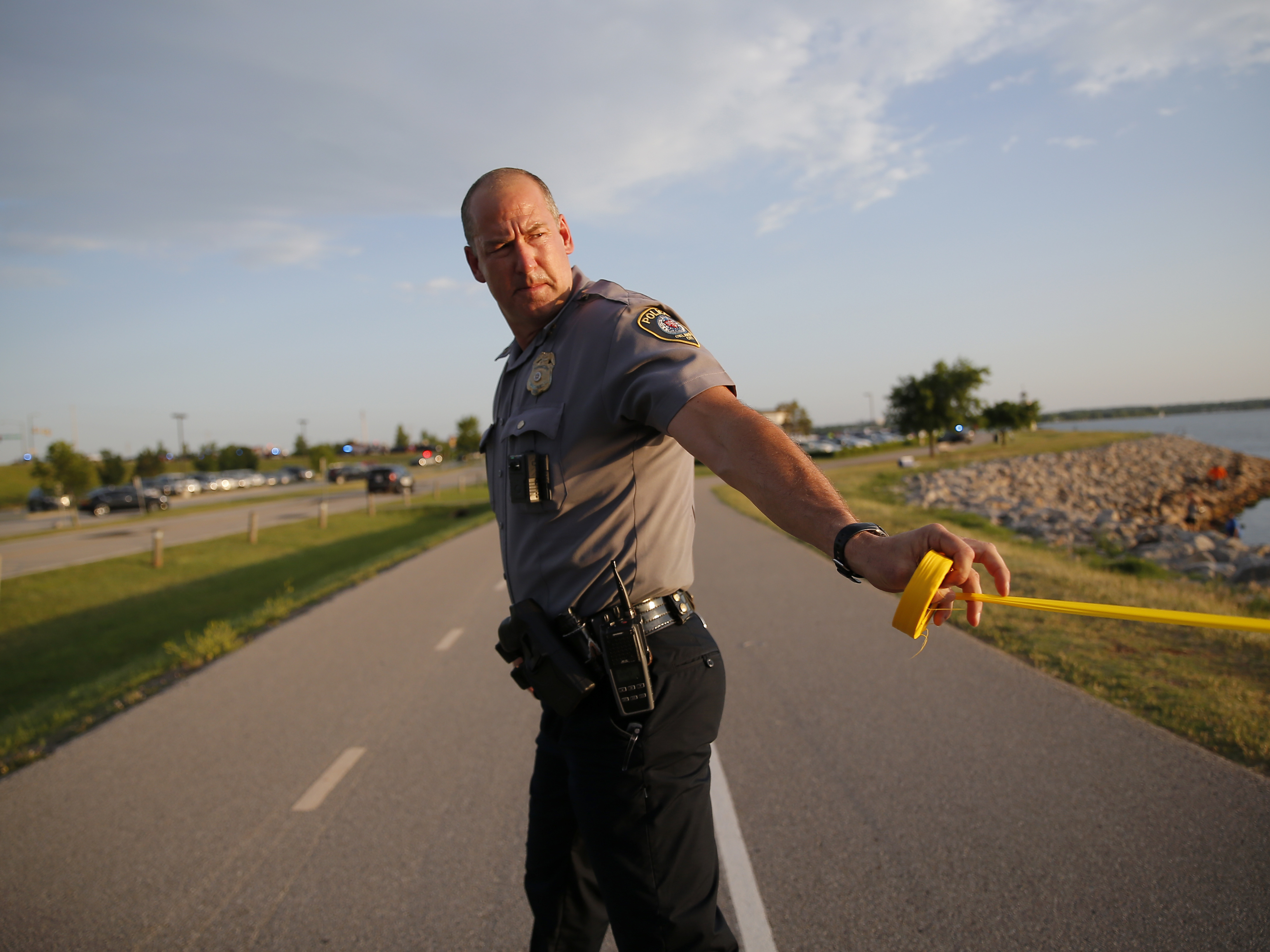 A police officer cordons off the scene of a Thursday night shooting at Louie's Grill & Bar in Oklahoma City.