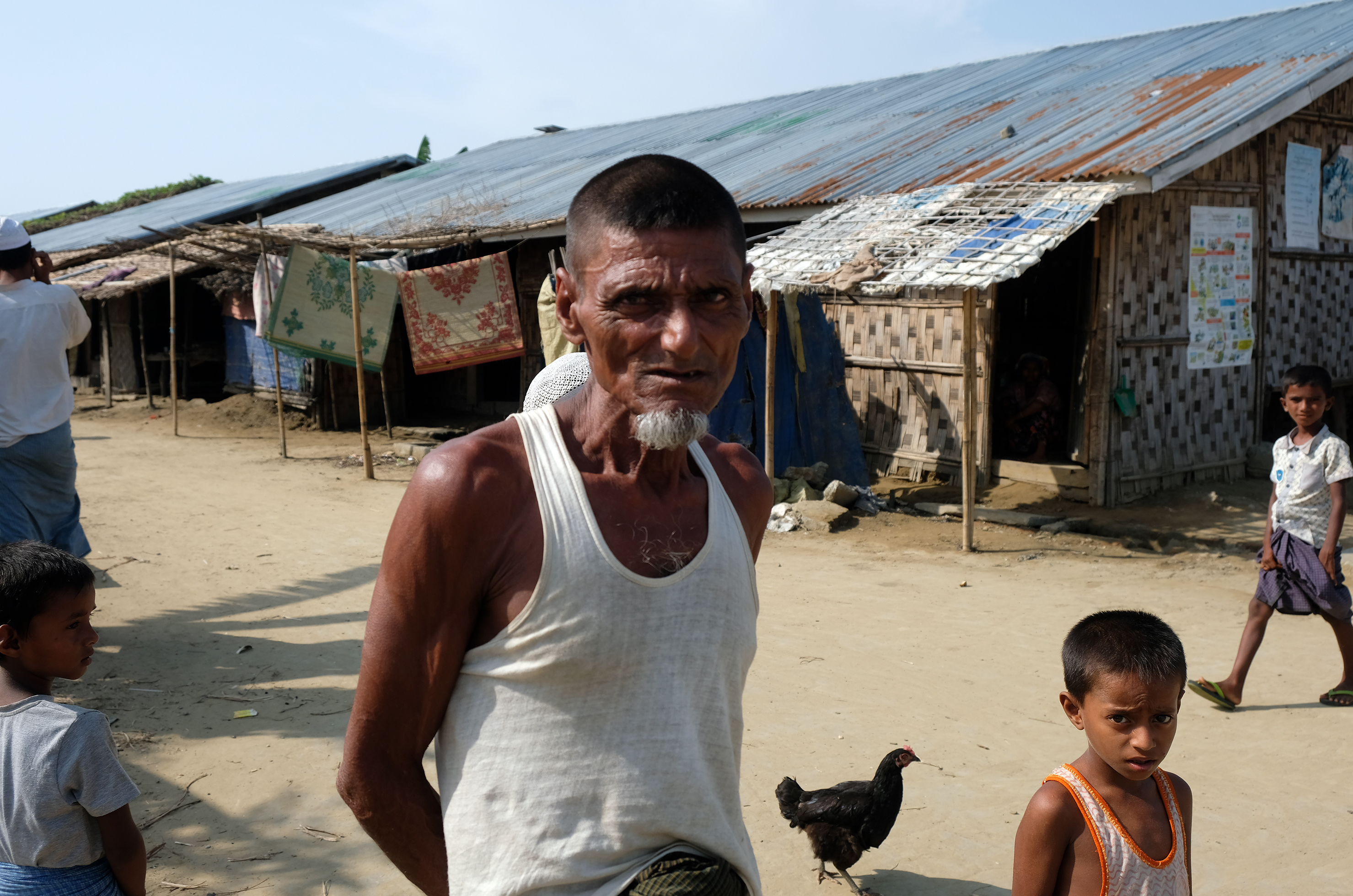 Residents of Myanmar's Thet Kae Pyin internment camp for Rohingya wait as a U.S. government delegation visits the camp. (NPR)