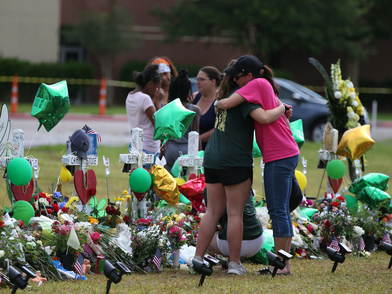 People mourn last week at a makeshift memorial in memory of the victims killed in a shooting at Santa Fe High School in Santa Fe, Texas. Students resumed classes at the school today. (Loren Elliott/Reuters)