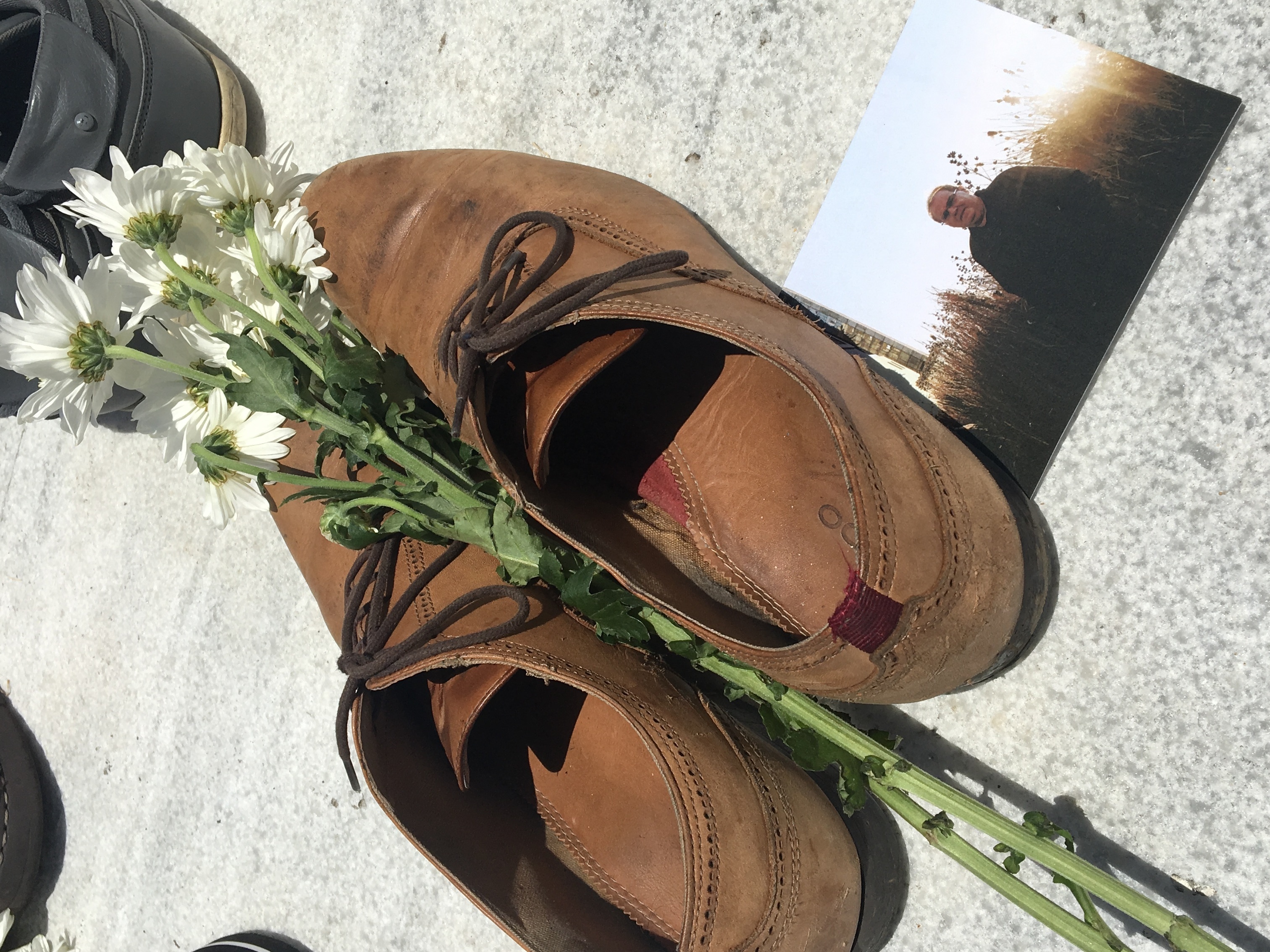 Luis Vázquez placed his shoes at the memorial in remembrance of his father, Luis Manuel Vázquez, who was found dead in his home two weeks after Hurricane Maria. (NPR)