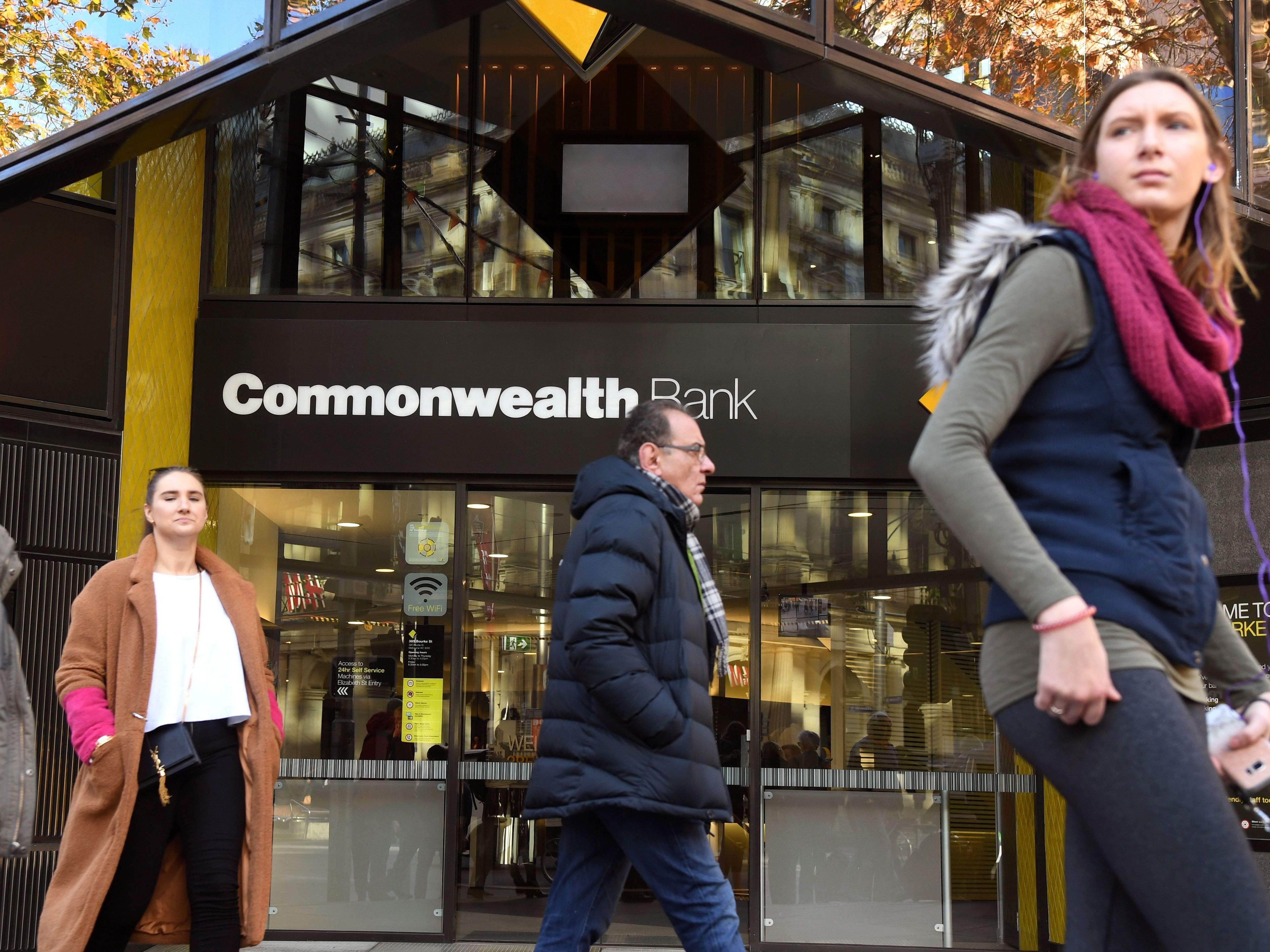 People walk past a branch of Australia's Commonwealth Bank in Melbourne on Monday. The Commonwealth Bank agreed to the largest civil penalty in Australian corporate history to settle claims it breached anti-money laundering and counter-terrorism financing laws. (AFP/Getty Images)