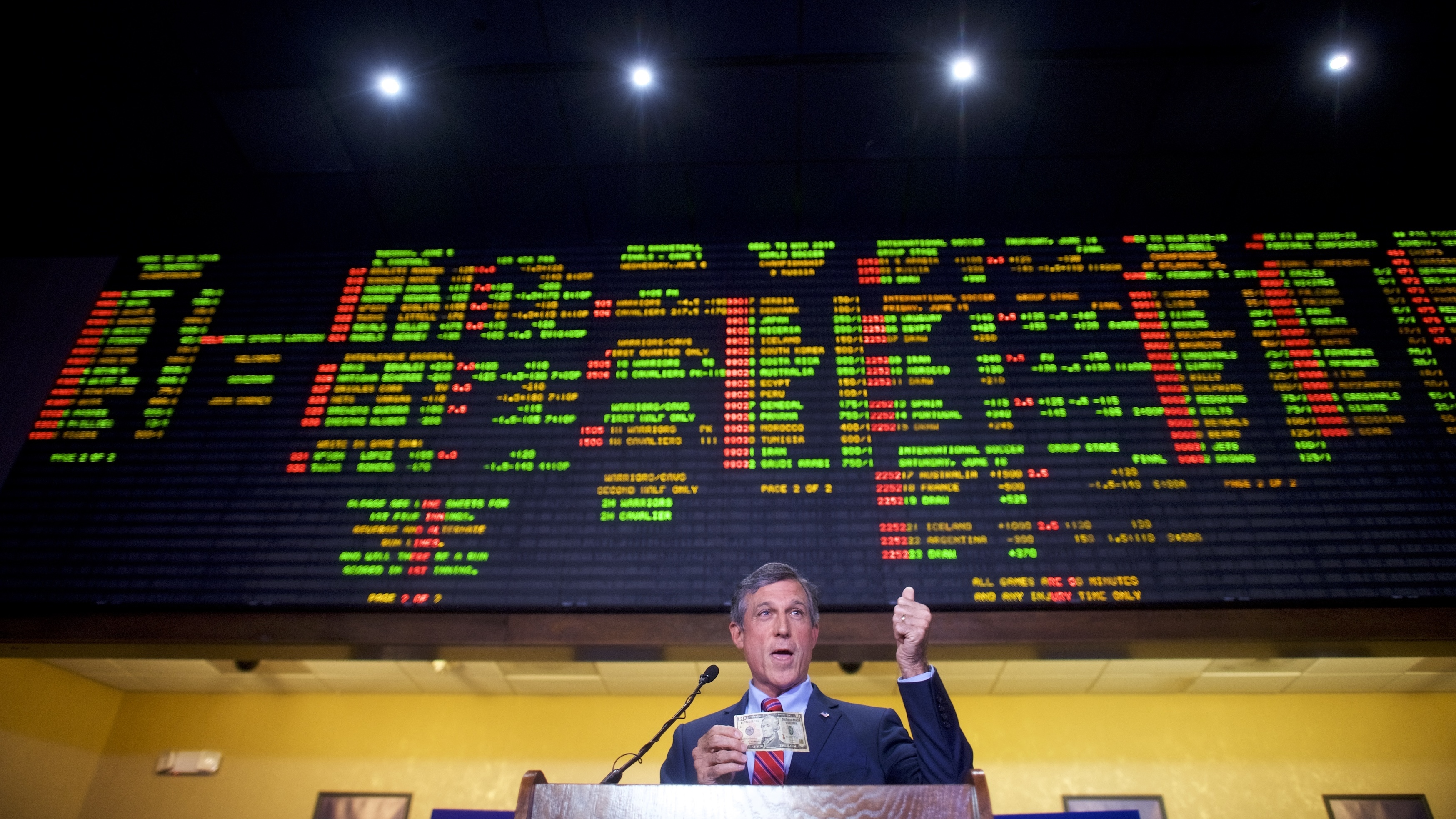 Delaware Gov. John Carney holds a $10 bill he used to place the first bet at Dover Downs Casino on Tuesday in Dover, Del. Delaware is the first state to launch legal sports betting since a Supreme Court decision allowed states to legalize such gambling. (Getty Images)