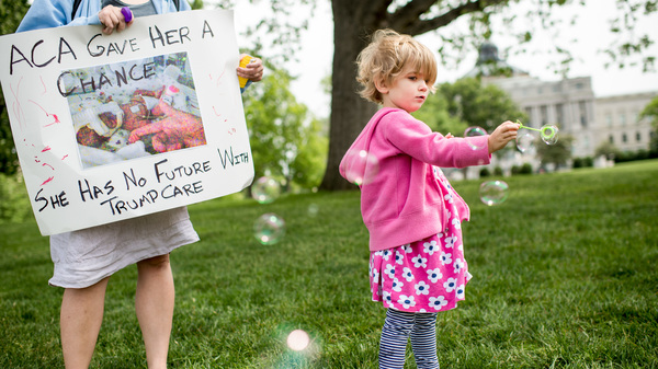 Charlie Wood, right, of Charlottesville, Va., plays with bubbles during a rally near the Capitol to oppose proposed changes to the Affordable Care Act on May 4, 2017. Charlie was born a few months prematurely, and her mother Rebecca, left, fears changes to the health law will negatively affect her care.