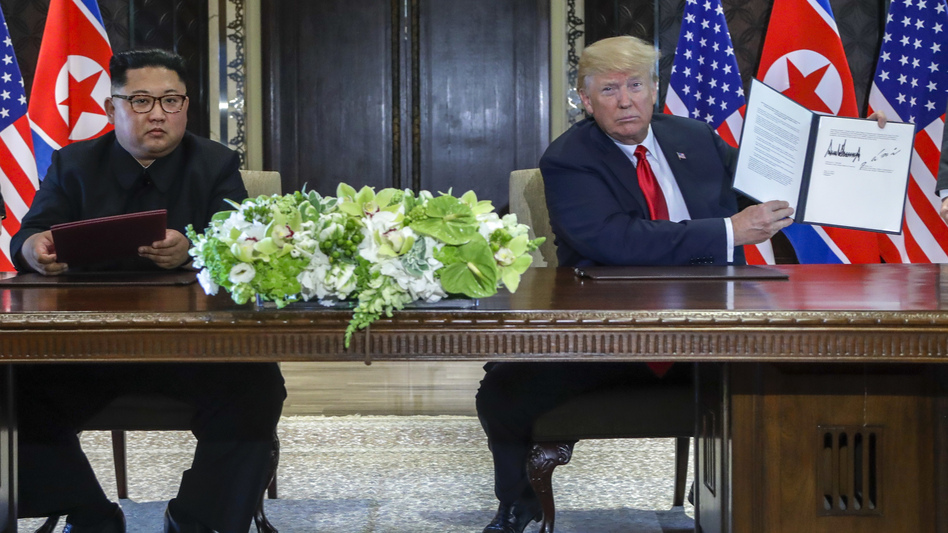 U.S. President Donald Trump holds up a document he and North Korean leader Kim Jong Un signed at the US North Korea summit in Singapore.