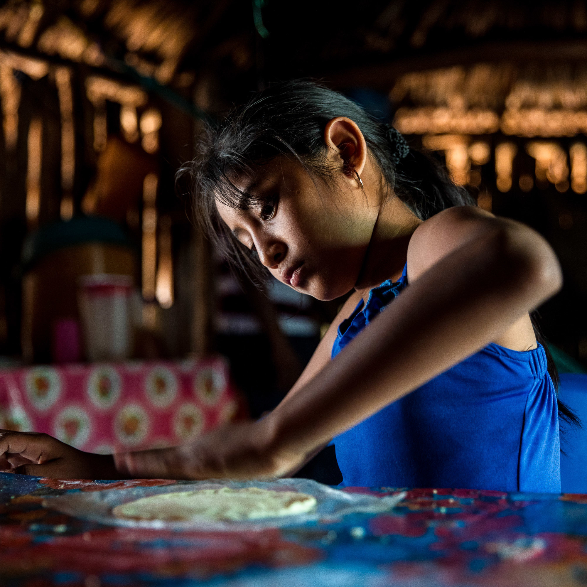Gelmy Tun Borgos helps in the kitchen making tortillas with her mother in their home in a small village in the Yucatan. (Adriana Zehbrauskas for NPR)