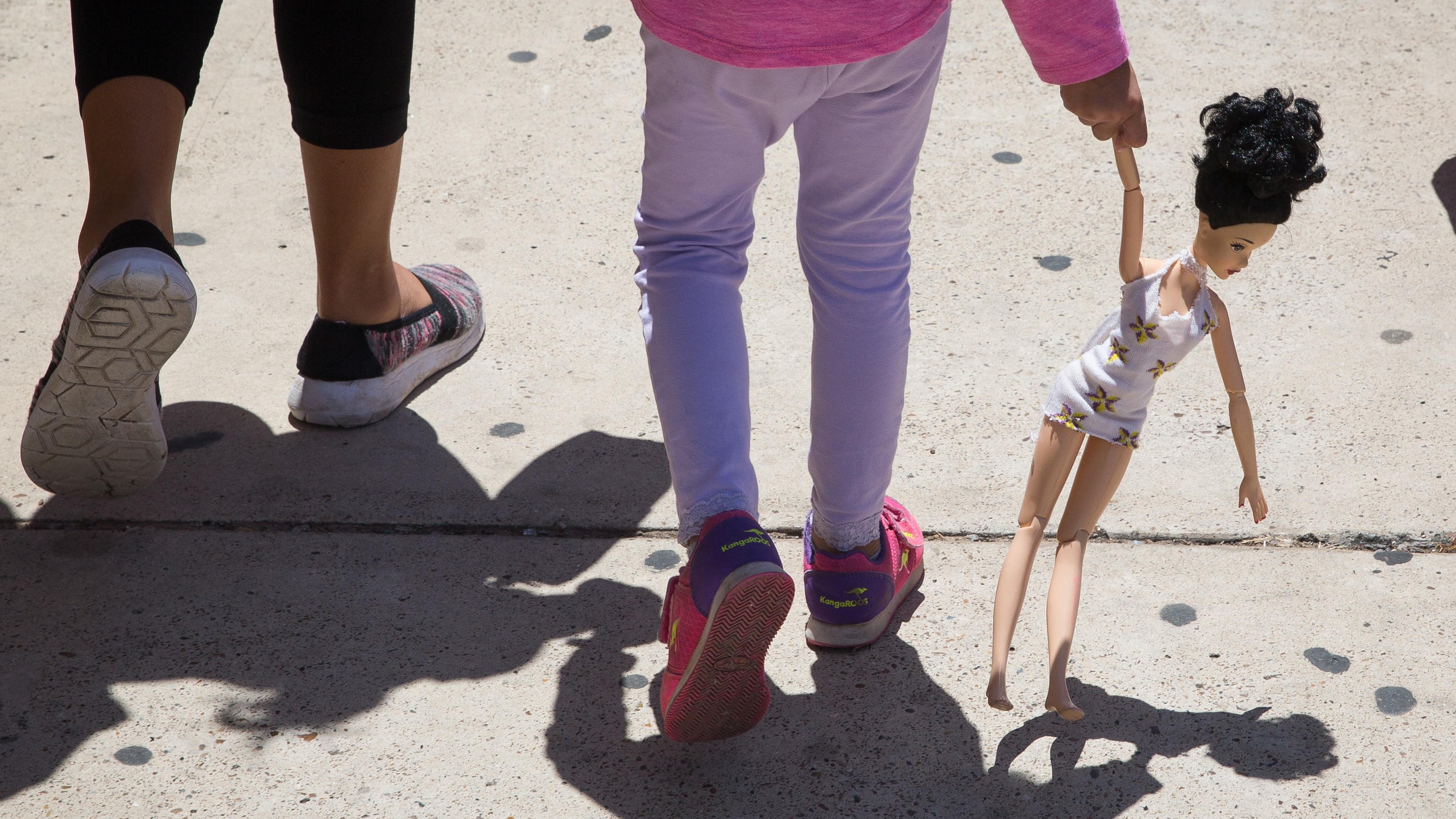 A 4-year-old Honduran girl carries a doll while walking with her immigrant mother. Both were released Sunday from federal detention in McAllen, Texas. (AFP/Getty Images)