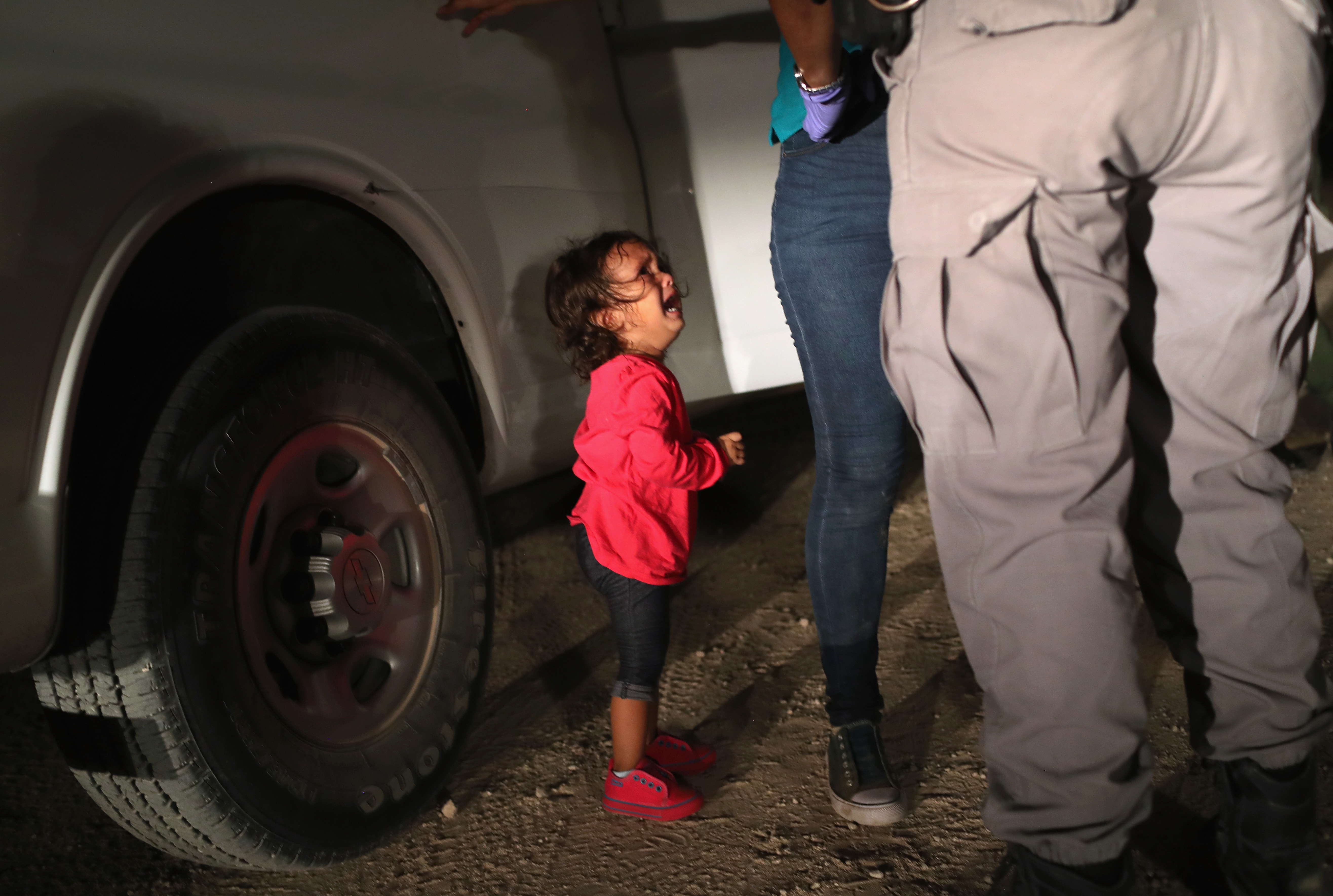 A 2-year-old Honduran girl cries as an official searches her mother in McAllen, Texas, near the U.S.-Mexico border, earlier this month. For many, the image has become indelibly associated with a Trump administration policy that for weeks separated migrant children from their parents — but the girl's father says she was not separated from her mother. (Getty Images)