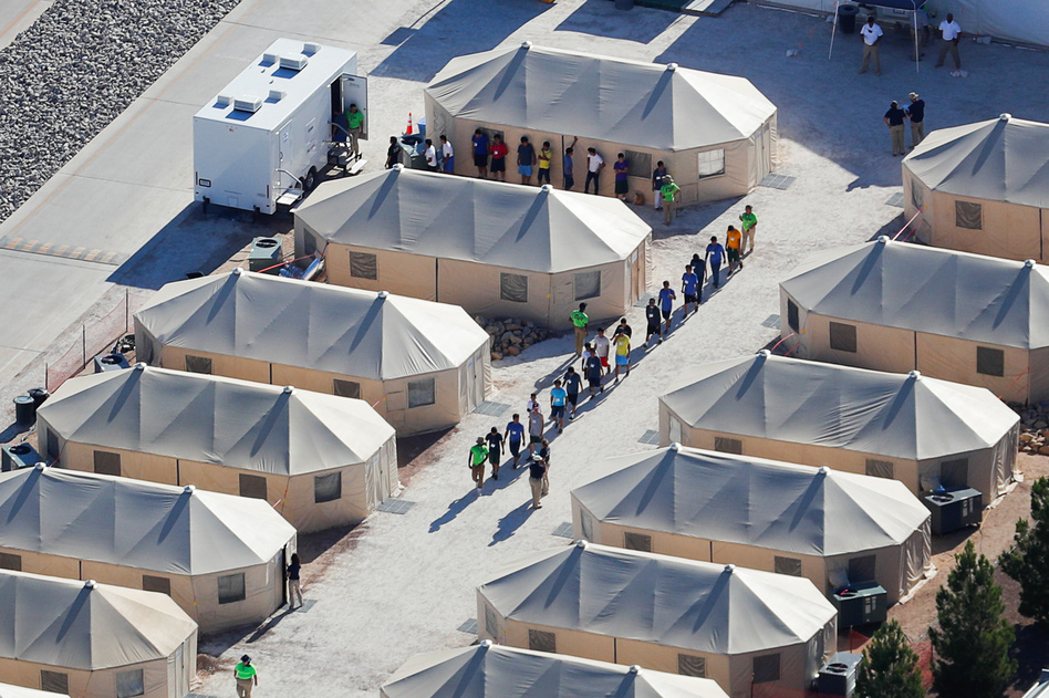 Migrant children now housed in a tent encampment under the Trump administration's "zero tolerance" policy are shown walking in single file at the facility near the Mexican border in Tornillo, Texas, on June 19. (Mike Blake/Reuters)