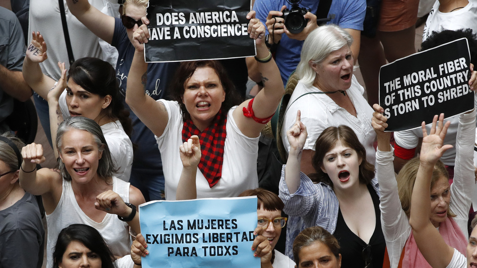 Women hold signs as they protest the separation of immigrant families inside the Hart Senate Office Building on Capitol Hill in Washington. (Jacquelyn Martin/AP)