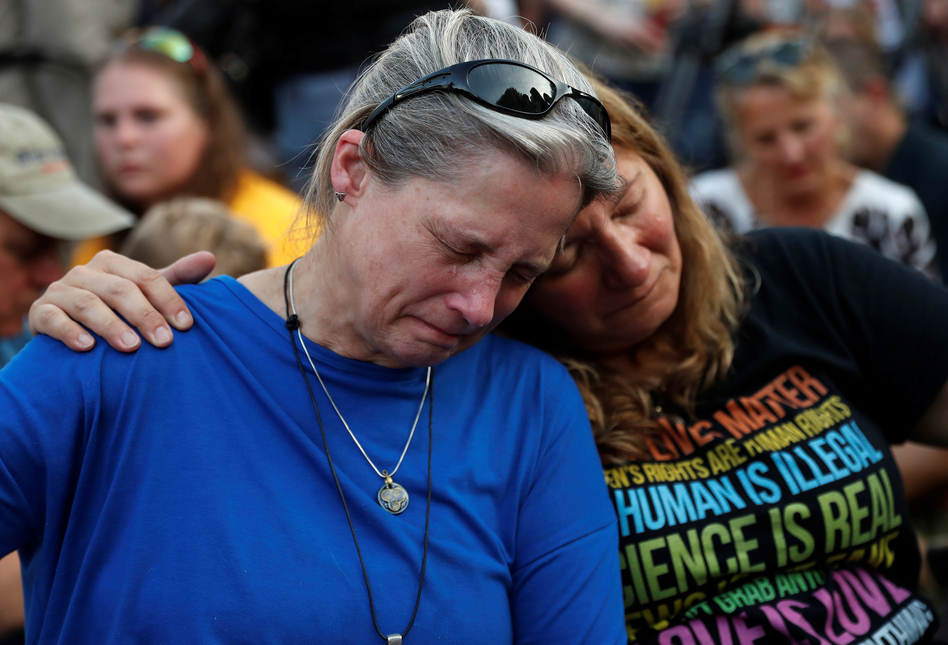 Community members Carol Geithner, left, and Yasemine Jamison take part in a candlelight vigil near the Capital Gazette, the day after a gunman killed five people inside the newspaper's building in Annapolis. (Leah Millis/Reuters)