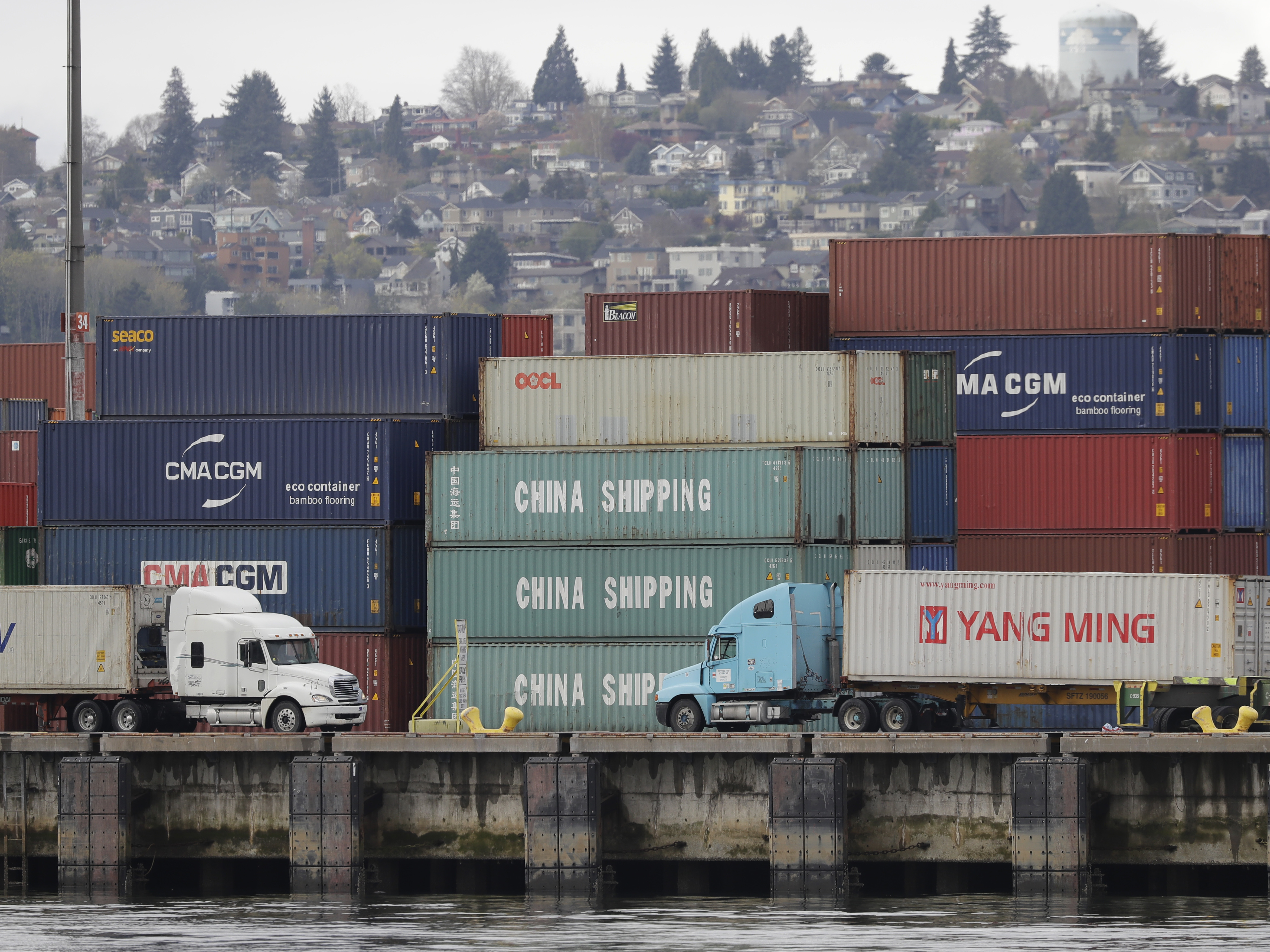 Trucks pass by cargo containers April 6 in Seattle. President Trump is preparing to impose tariffs on an additional $34 billion in Chinese imports on Friday, a move that China has promised to match.