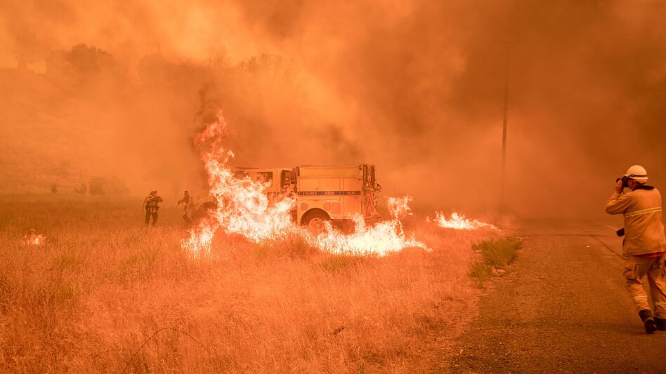 Firefighters scramble to control flames surrounding a fire truck as the Pawnee Fire jumps across a highway near Clearlake Oaks, Calif. (Josh Edelson/AFP/Getty Images)