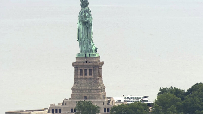 activists arrested at statue of liberty after protesting trump s