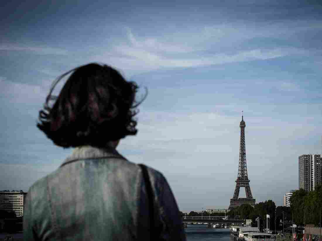 A woman stands on a bridge in front of the Eiffel tower in Paris on June 24, 2018. (Photo by Philippe LOPEZ / AFP) (Photo credit should read PHILIPPE LOPEZ/AFP/Getty Images)