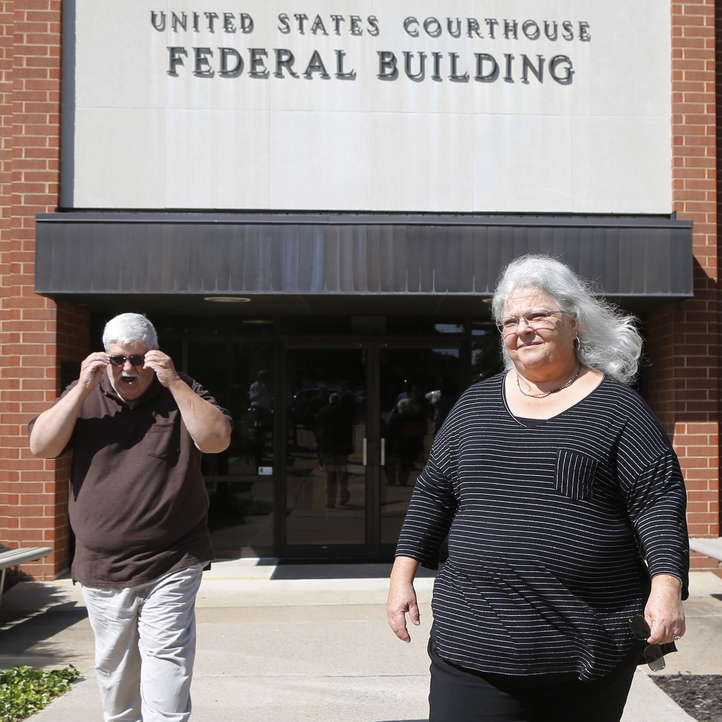 Susan Bro, the mother of Charlottesville car attack victim Heather Heyer, walks out of federal court in Charlottesville, Va., with her husband on Thursday following a hearing at which James Alex Fields Jr. pleaded not guilty to multiple federal hate crime charges.