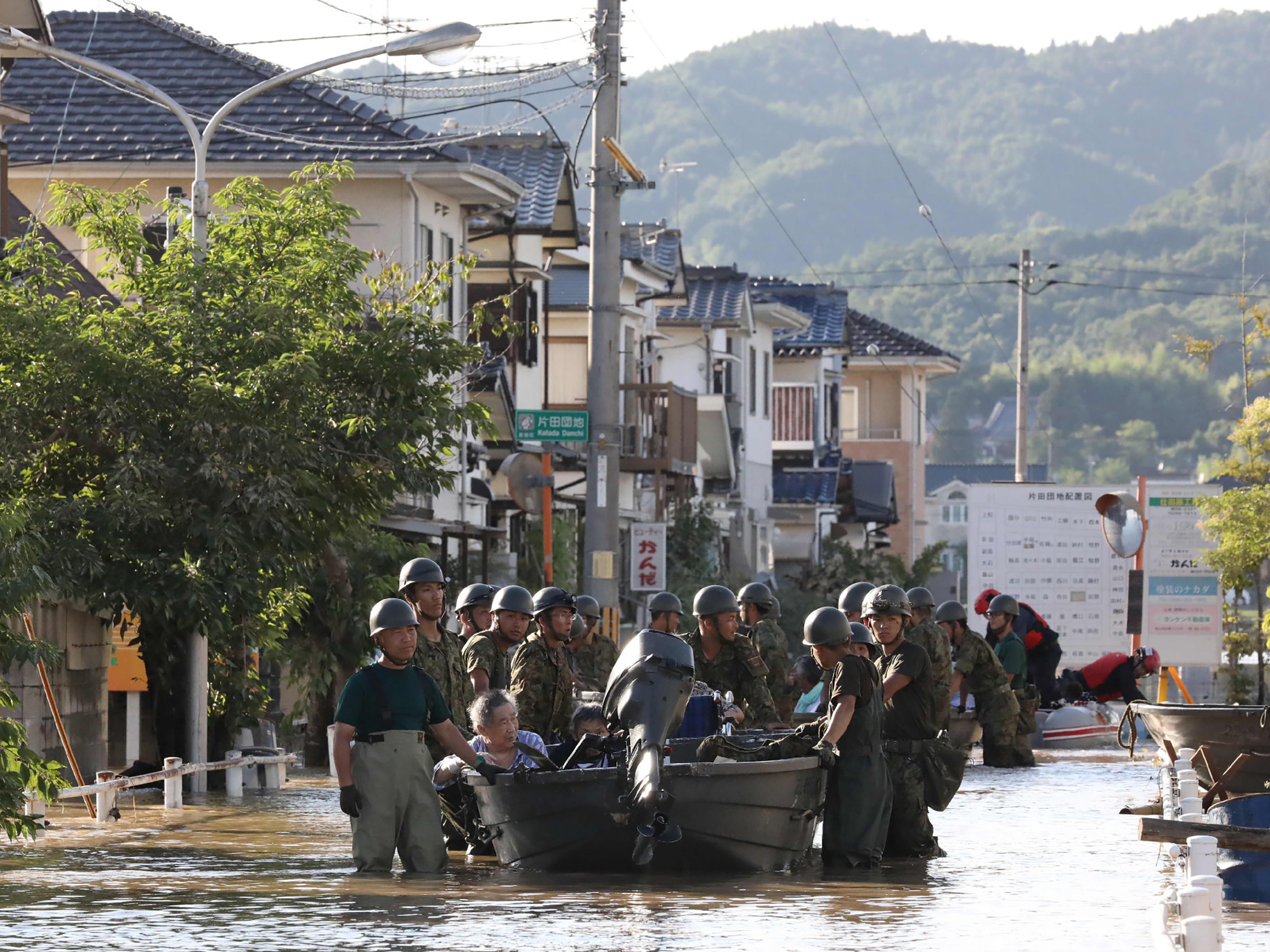 Japan's Self-Defense Forces use boats to rescue people from Mabi Memorial Hospital, which was isolated after flood damage.
